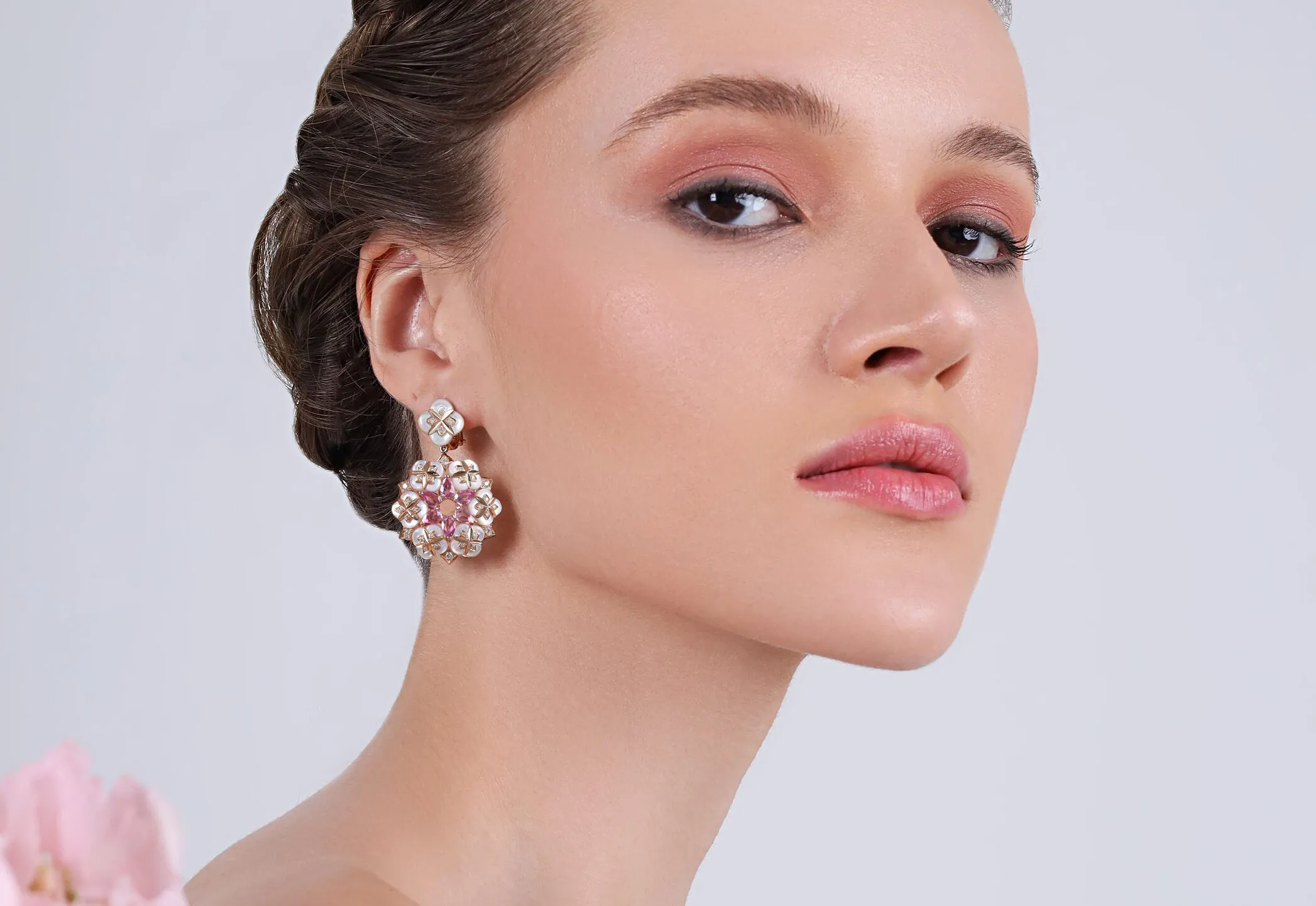 <p>A model wears earrings from the BijouQ Flora Geomatrica collection with mother of pearl and diamonds in 18k rose gold </p>
