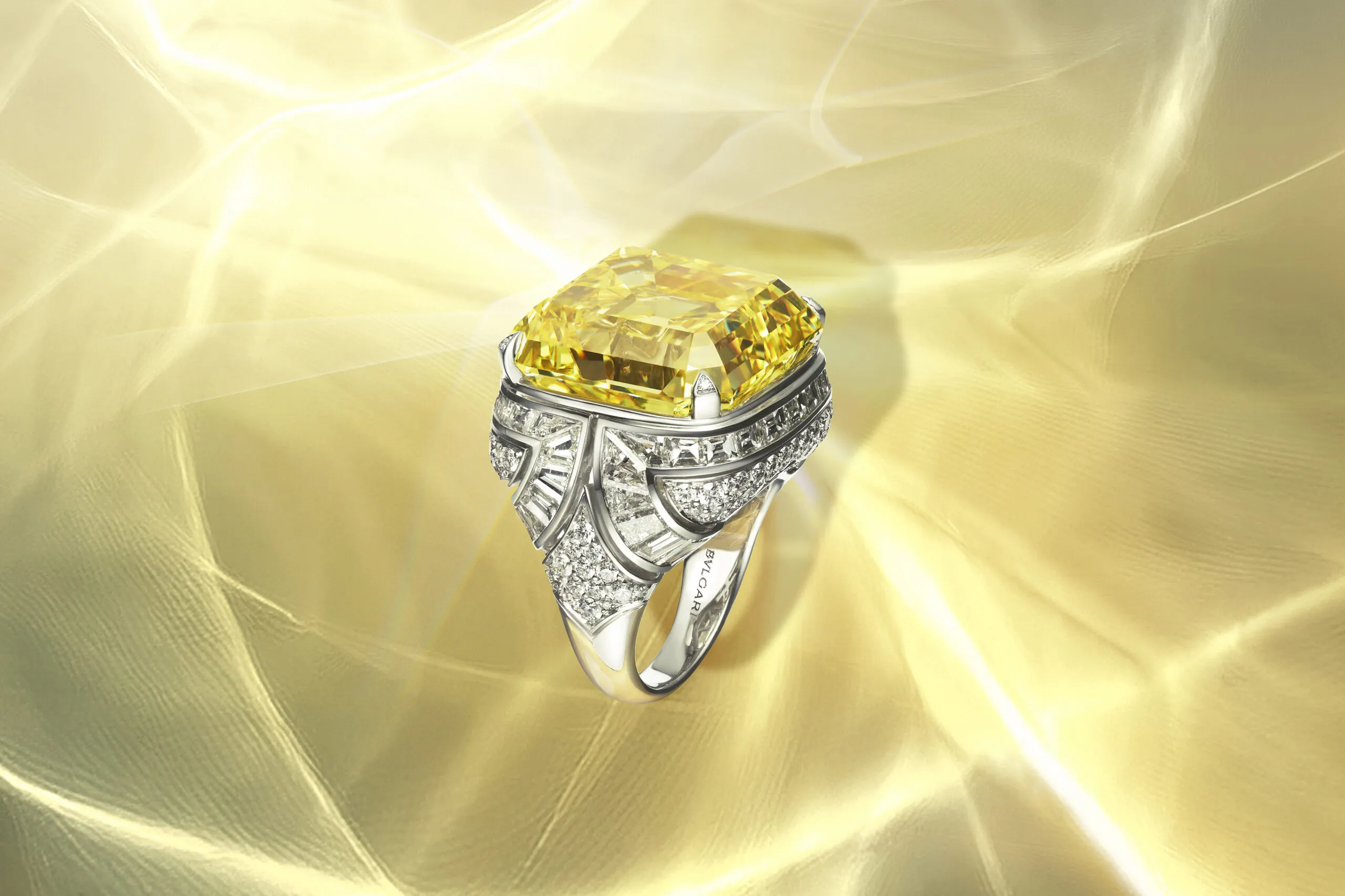 <p>The Essence of Yellow ring features a 45-carat fancy vivid yellow diamond in an Asscher emerald shape in a shank decorated with graphic arch shapes rendered in step-cut diamonds. Bvlgari Polychroma High Jewellery 2025</p>