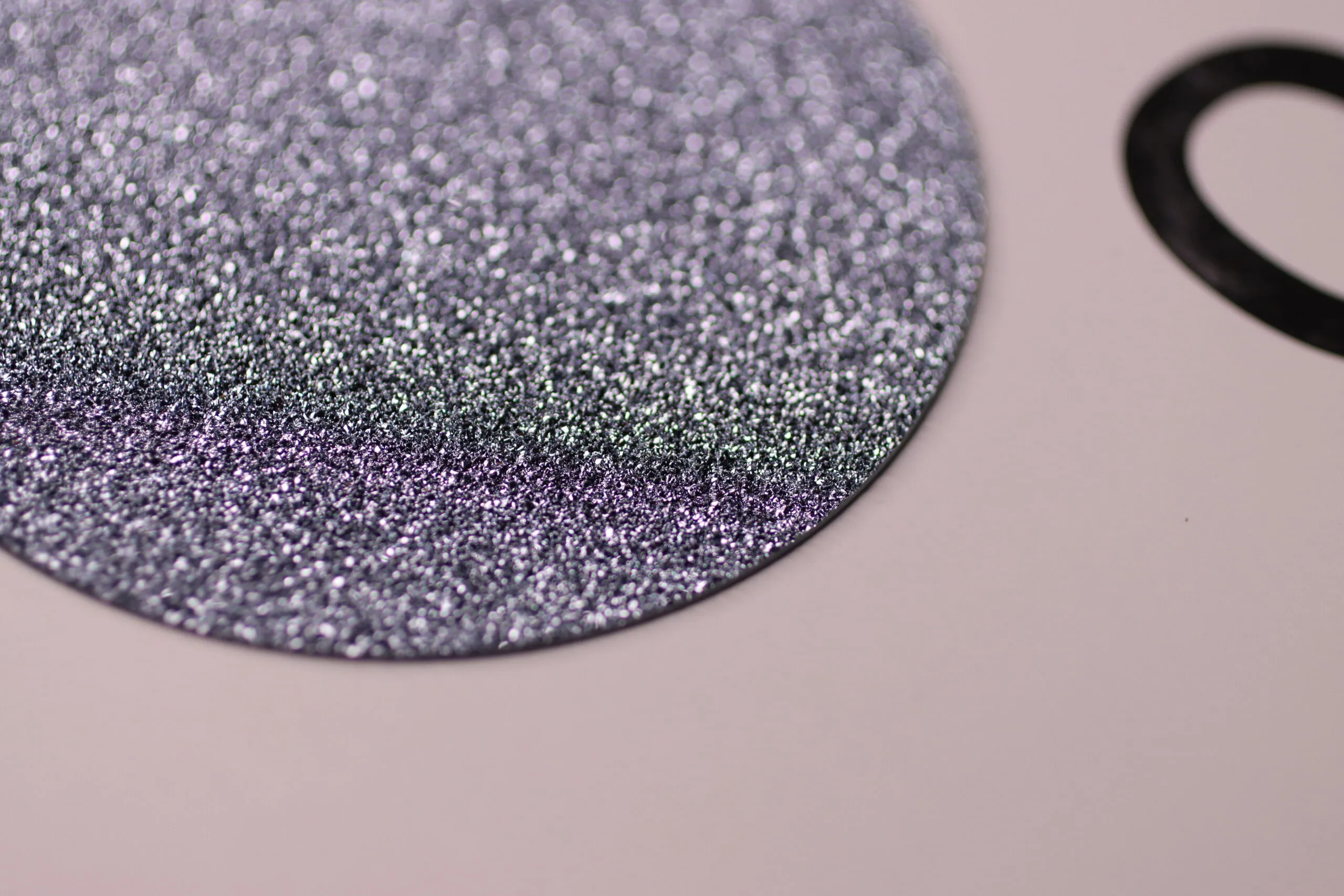 <p>Close-up of a flat crystalline osmium disc, showing its surface</p>