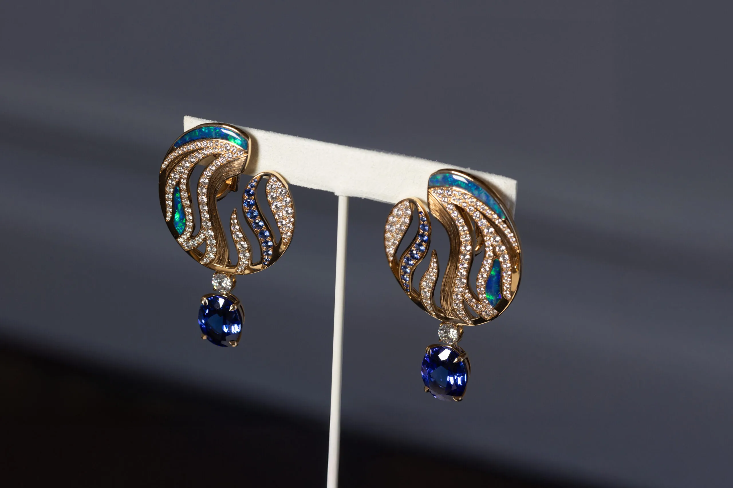<p>The matching high jewellery earrings feature psychedelic swirls of engraved gold, set with opal, diamonds and sapphires.</p>
