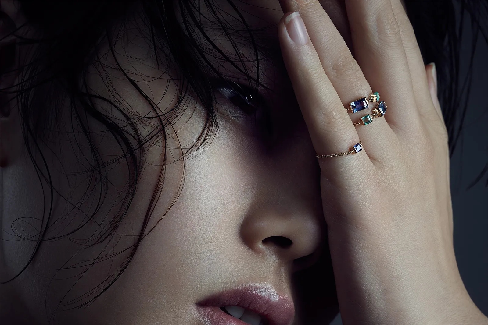 <p>A model wears a selection of Yi Collection Chain rings with emerald and topaz set in 18k yellow gold</p>