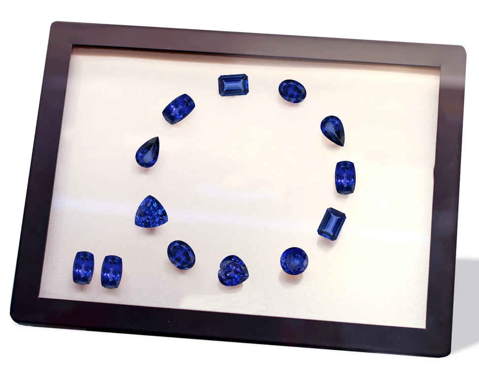 <p>A selection of loose tanzanite gemstones presented in a necklace and earrings layout by Royal Touch Group </p>
