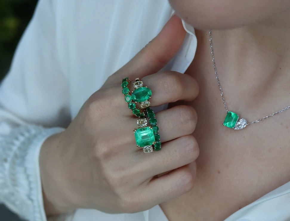 <p>Katerina Perez wears emeralds by Valentina Fine Jewellery, including two emerald eternity rings, an oval-shaped emerald trilogy ring with light yellow diamond side stones, an octagonal-shaped emerald-cut emerald with cushion-cut diamond side stones, and an emerald and diamond toi et moi style necklace with a 3.60-carat Colombian emerald and a 1.22 carat pear-shaped diamond</p>