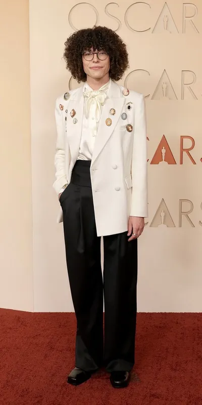 <p>Reece Feldman wears vintage brooches and Omega 30mm Seamaster Aqua Terra in Moonshine Gold, set with diamonds</p>
