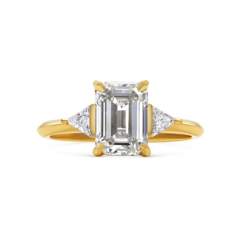 <p>Rachel Boston Crux emerald cut diamond engagement ring in 18K yellow gold.</p>