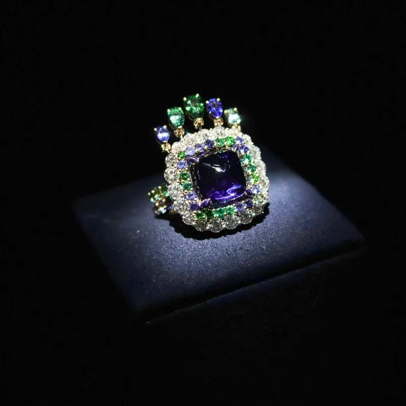 <p>A sugarloaf tanzanite ring in the Belle Dior High Jewellery collection by Dior Joaillerie, surrounded by diamonds and further coloured gemstones</p>
