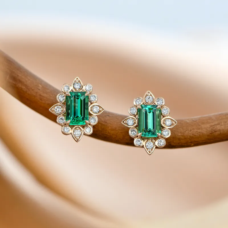<p>A pair of earrings in 18k rose gold set with two emeralds totalling 0.82 carats and 24 G/VS1 diamonds</p>