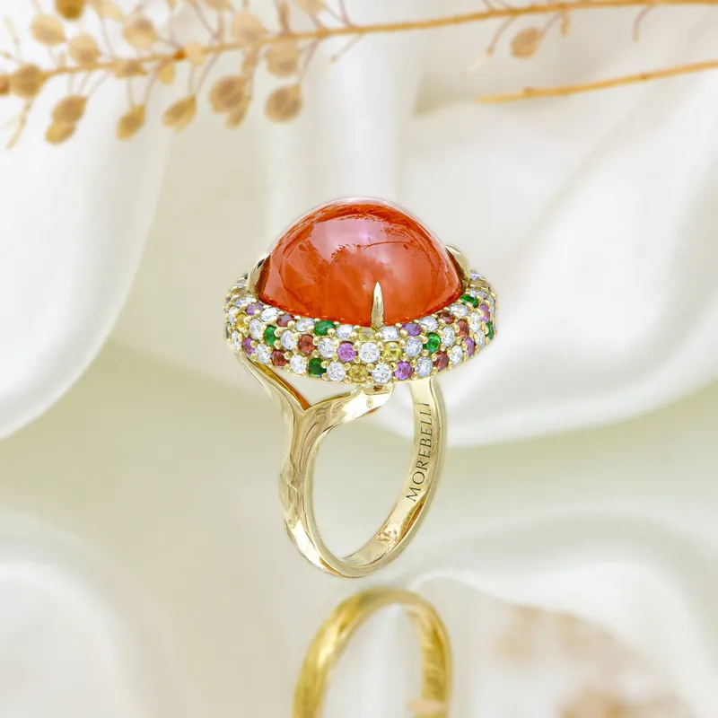 <p>Cocktail ring in 18k yellow gold with a 23.56 carat spessartite cabochon, 13 pink sapphires, 13 orange sapphires, 13 tsavorites, 13 yellow sapphires and 52 diamonds totalling 1.92 carats</p>