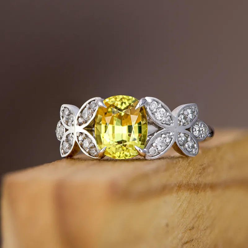 <p>An 18k white gold ring set with a 1.67 carat oval-shaped yellow sapphire and 24 diamonds in a butterfly-inspired setting </p>