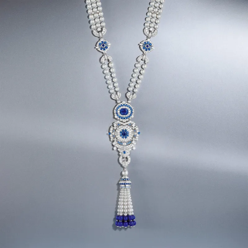 <p>Pompon Margaret long necklace watch in white gold with a 6.19 carat cushion-cut sapphire, lapis lazuli, sapphires, white cultured pearls, white mother-of-pearl, diamonds</p>