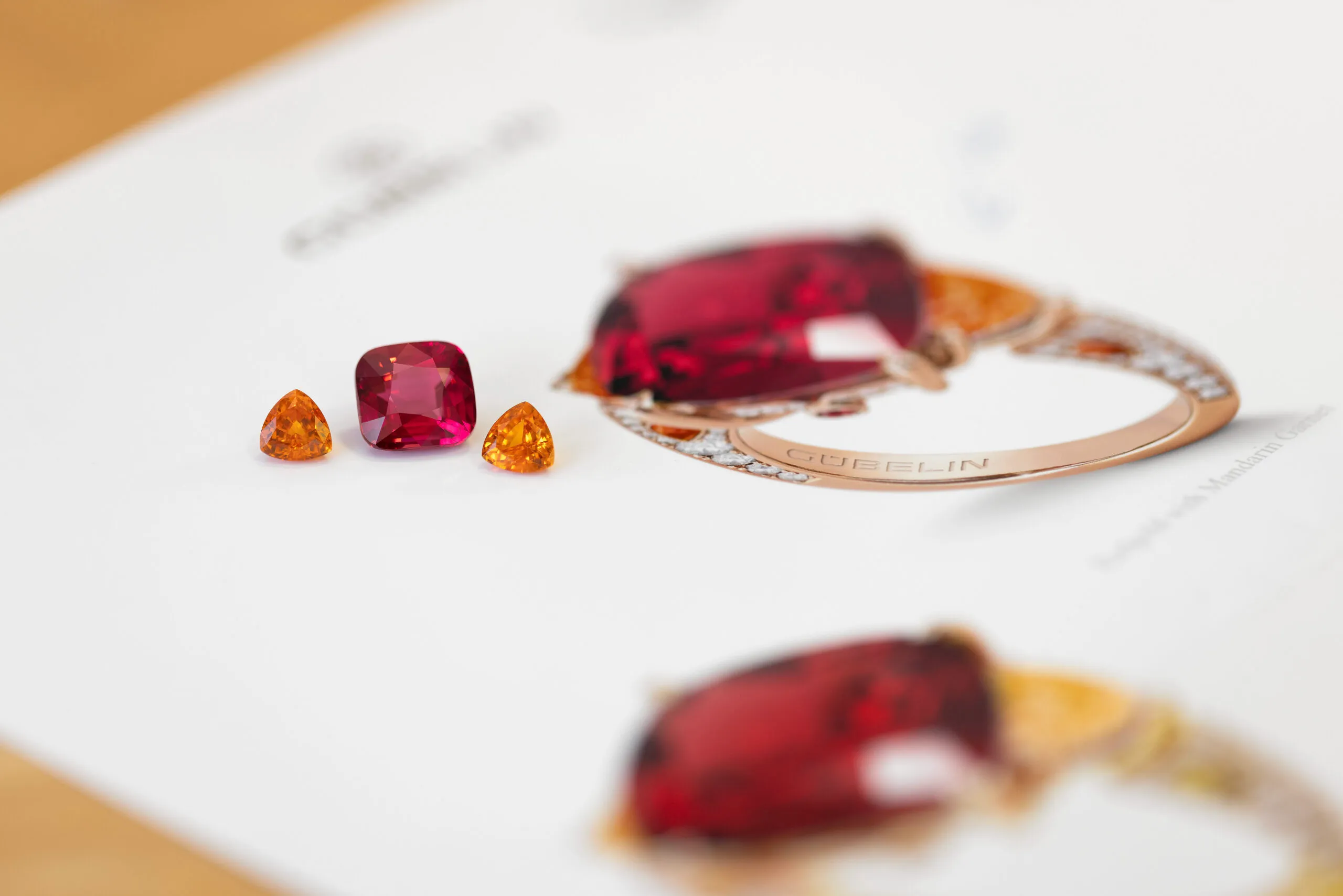 <p>House of Gübelin Classics spinel cocktail ring with a Tanzanian purplish-red spinel of over 9 carats flanked by two mandarin garnets and brilliant-cut diamonds in red gold</p>