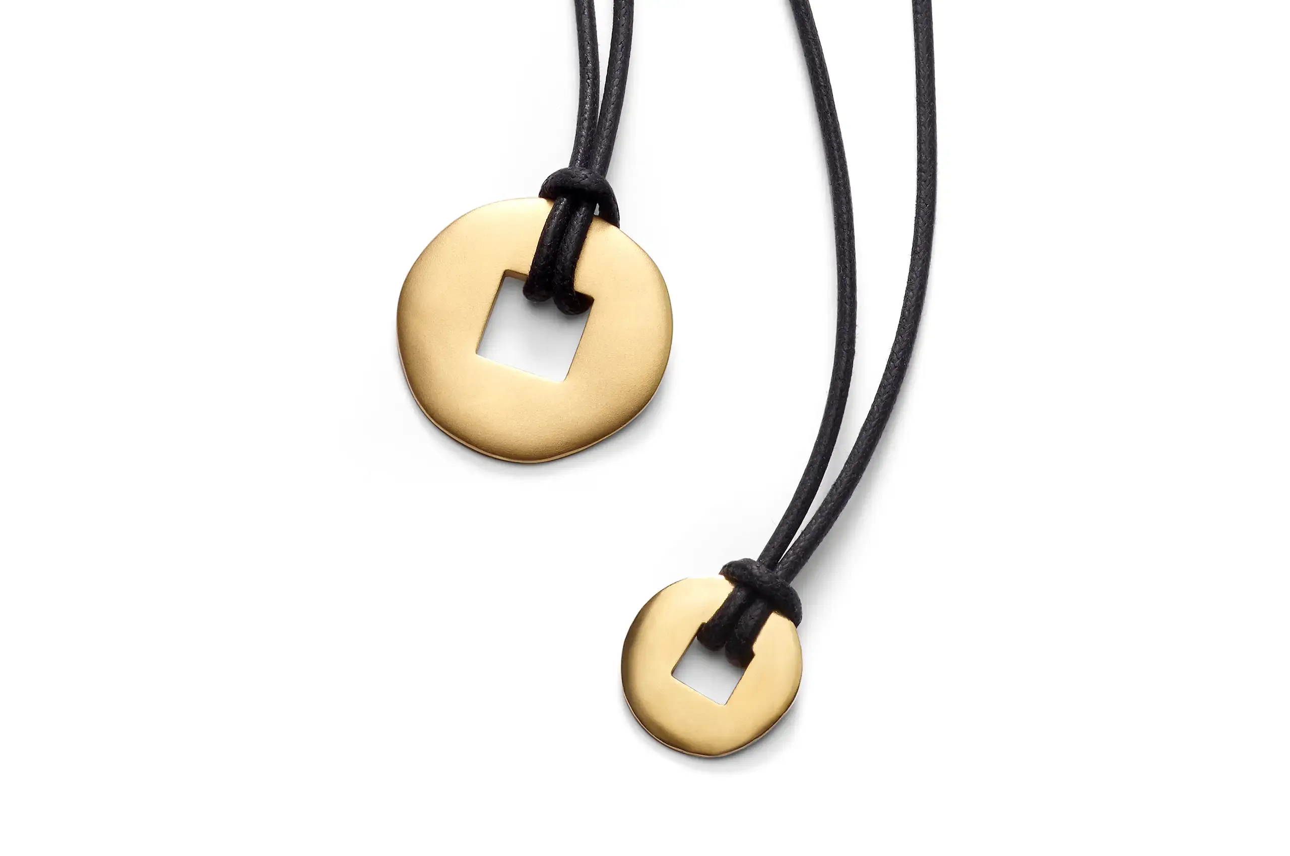 The original 1997 Moneta Orientale pendant by Pomellato, conceived as a minimal gold coin suspended from a black cord, forms the archival foundation of the 2026 reinterpretation.