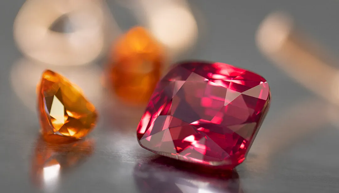 <p>House of Gübelin Classics spinel cocktail ring with a Tanzanian purplish-red spinel of over 9 carats flanked by two mandarin garnets and brilliant-cut diamonds in red gold</p>