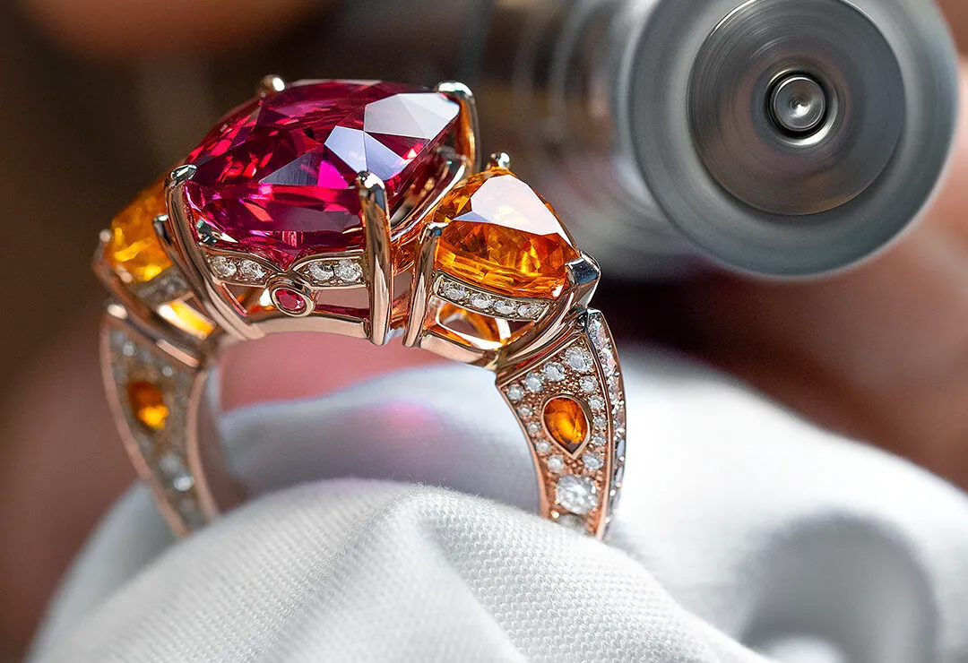 <p>House of Gübelin Classics spinel cocktail ring with a Tanzanian purplish-red spinel of over 9 carats flanked by two mandarin garnets and brilliant-cut diamonds in red gold</p>