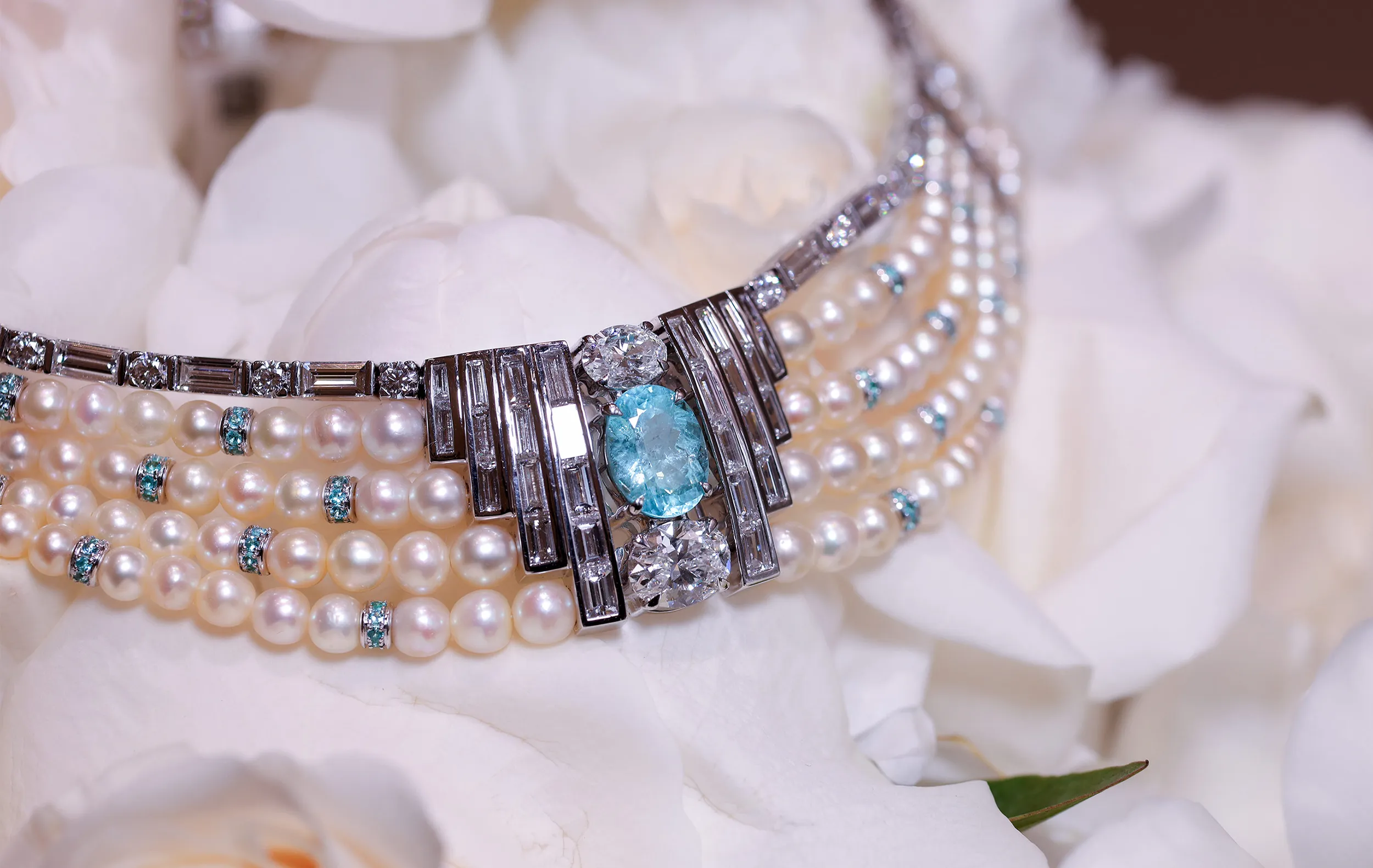 <p>The choker is finished with multiple strands of natural Bahraini pearls, punctuated by Paraiba accents in-between</p>
