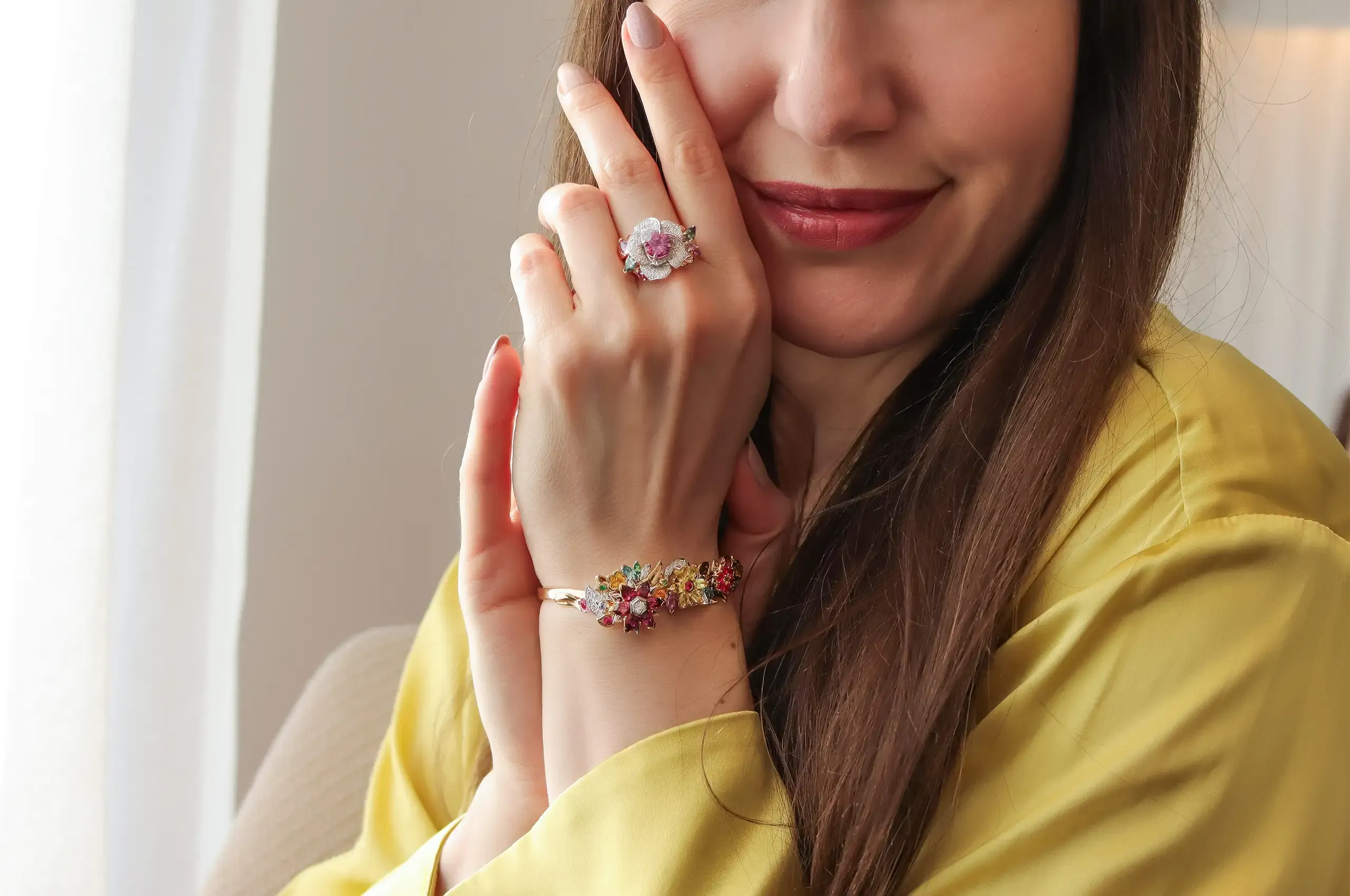 Katerina Perez wears the Artisans Bespoke Jewellers Botanica Lady Beetle ‘Rose’ ring with a 1.79 carat pink-purple sapphire surrounded by diamonds, and green, purple and pink sapphire leaves, set in 18k rose and white gold, and the Botanica bangle, set with sapphires, spinels, garnets, zircons and diamonds in 18k yellow and white gold 