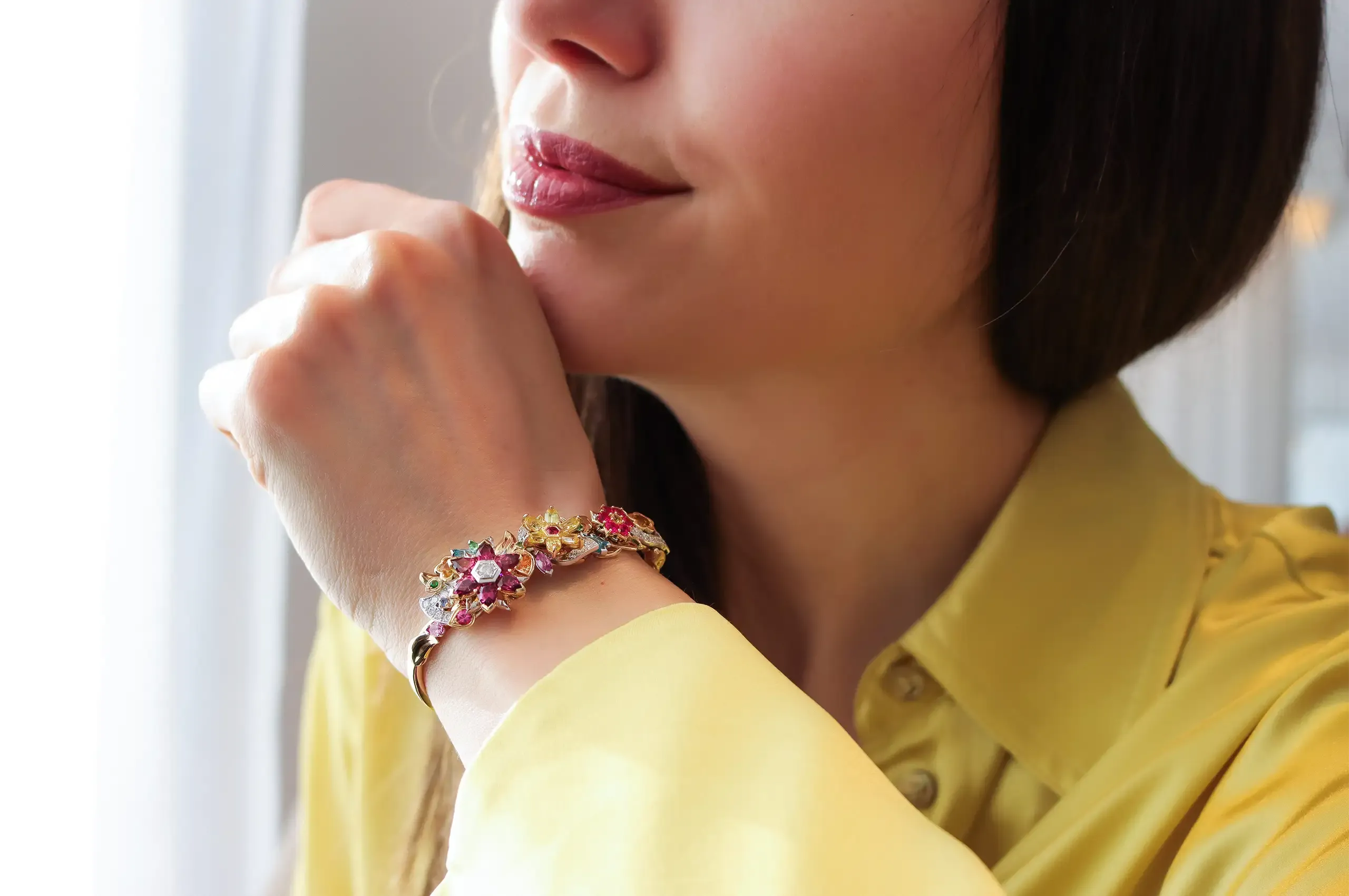Katerina Perez wears the Artisans Bespoke Jewellers Botanica bangle, set with sapphires, spinels, garnets, zircons and diamonds in 18k yellow and white gold 