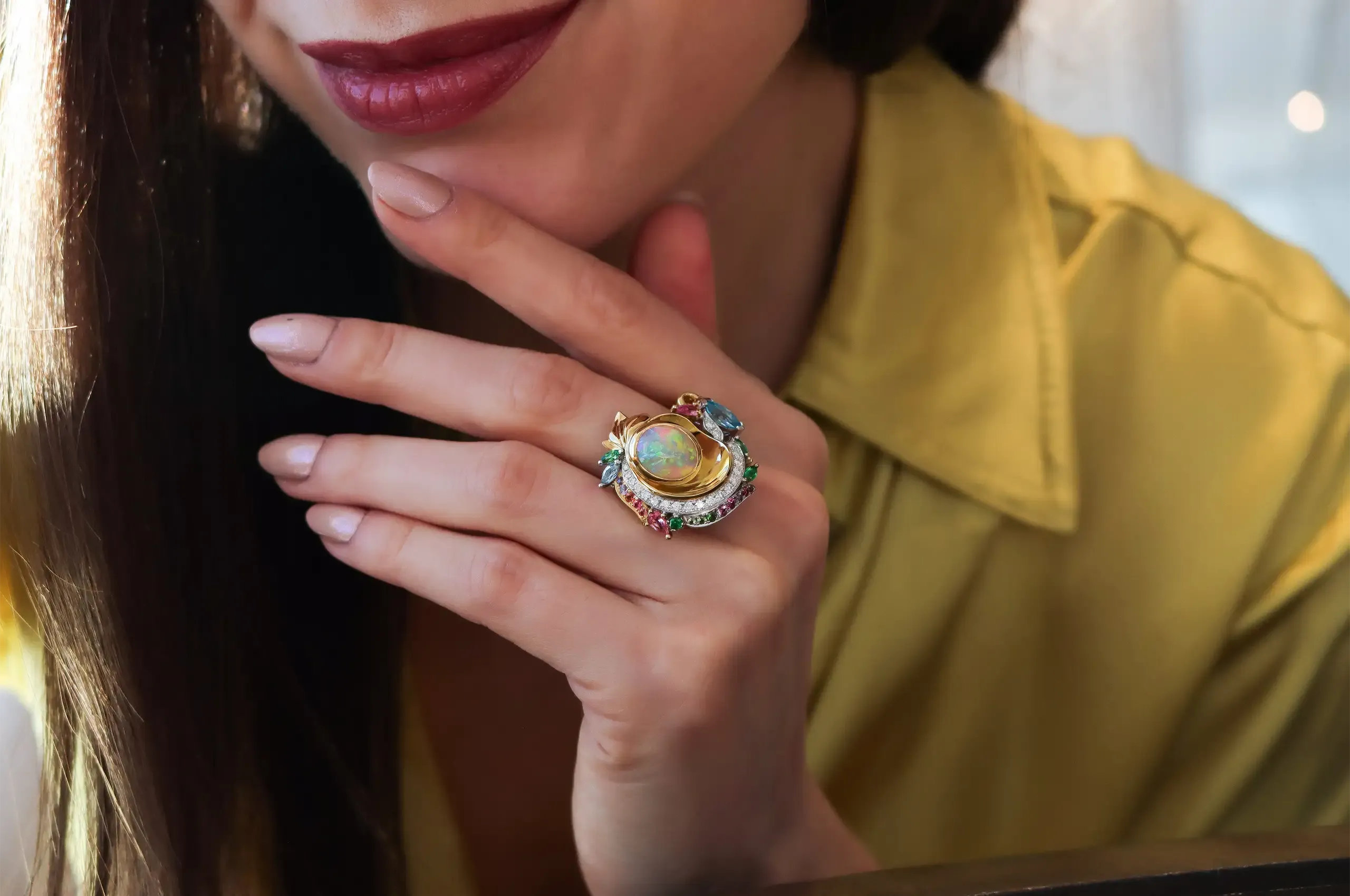 Katerina Perez wears Artisans Bespoke Jewellers’ award-winning Khroma ring with a 3.45 carat oval cabochon-cut crystal opal from Lightning Ridge and an intricate halo of zircon, sapphire, garnet, spinel and diamonds, set in 18k yellow and white gold 