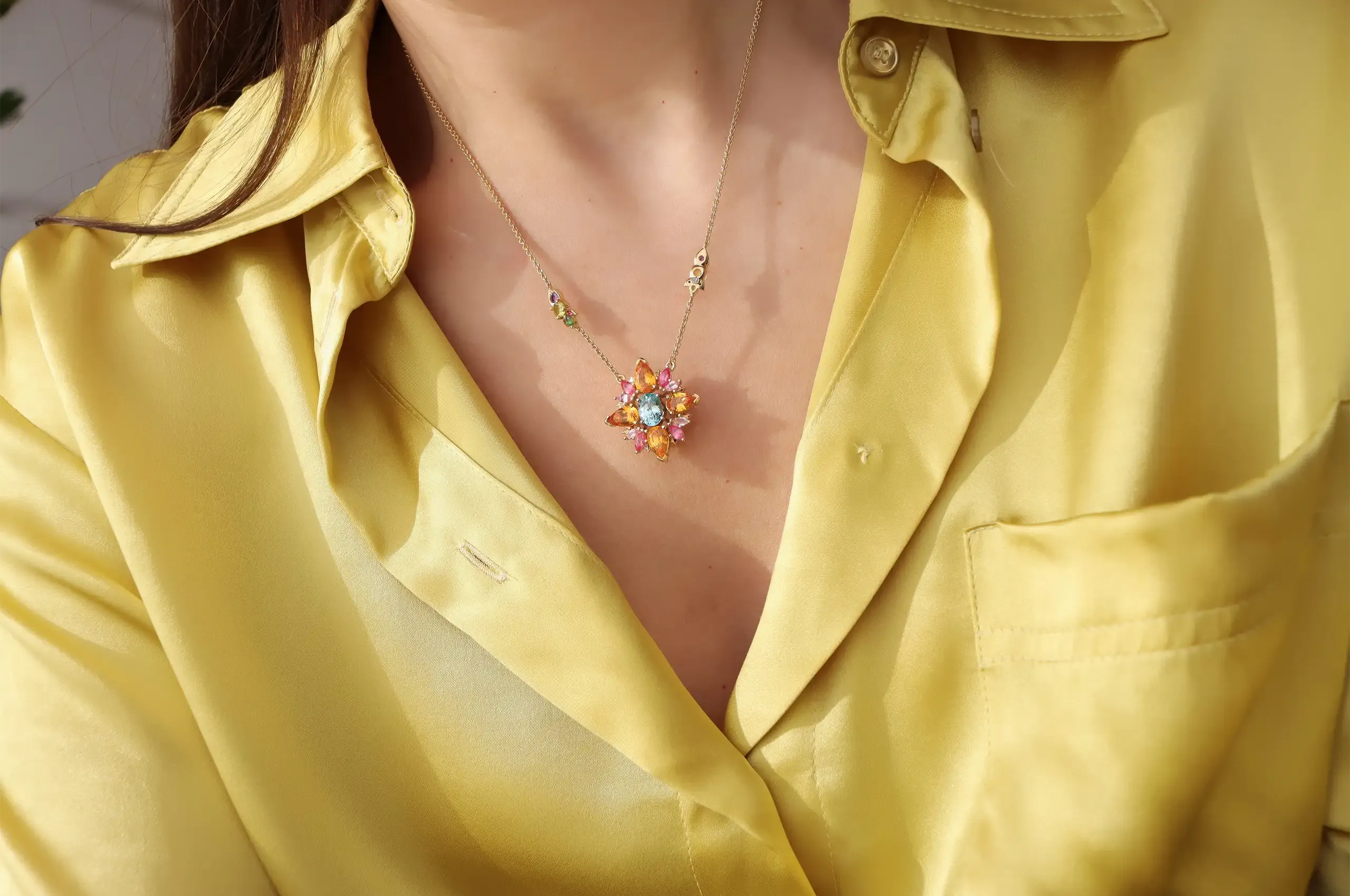 The Artisans Bespoke Jewellers Botanica pendant worn without its detachable aquamarine drop, set with sapphire, garnet, spinel, zircon and diamonds in 18k yellow and white gold 