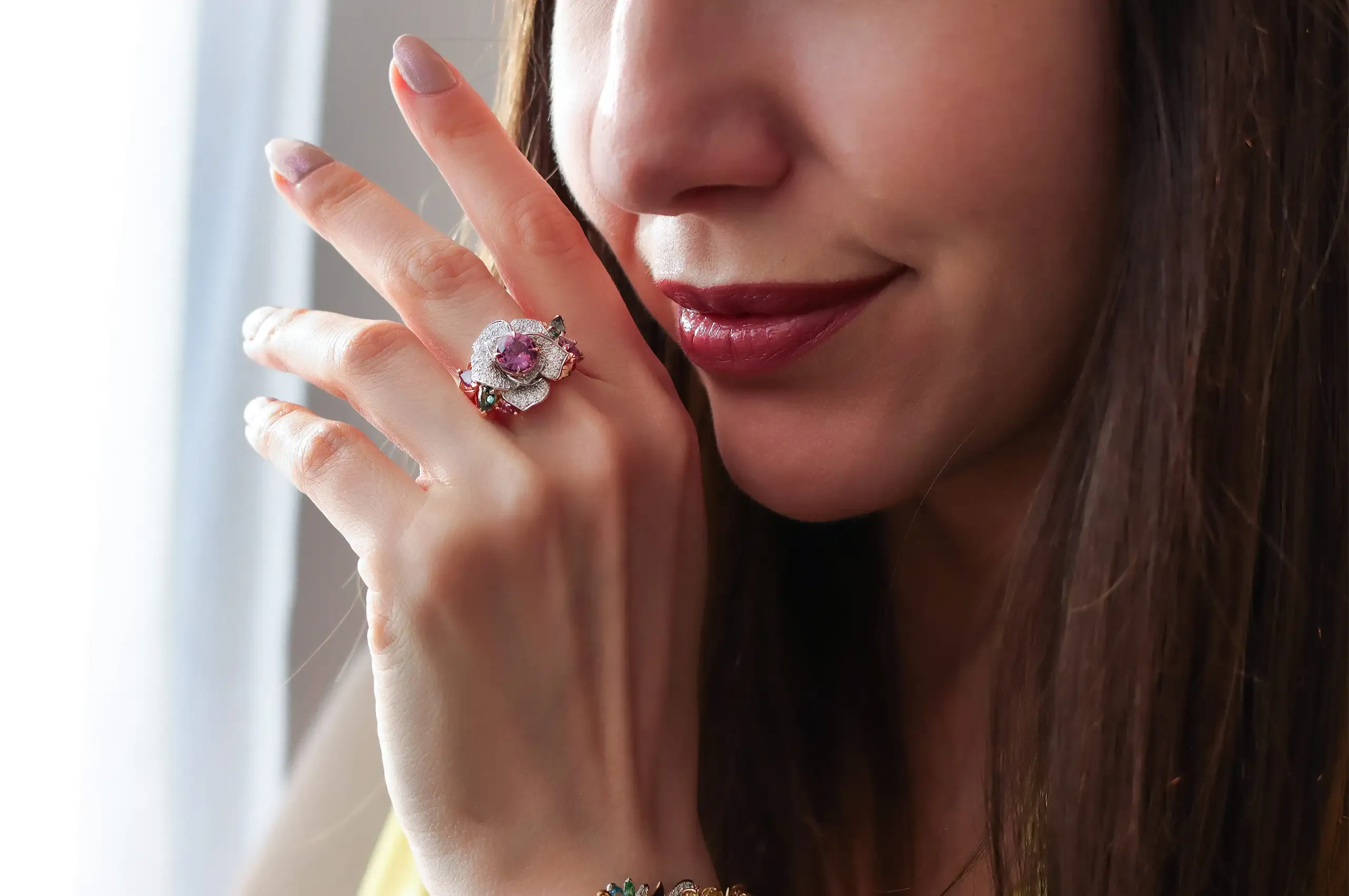 Katerina Perez wears the Artisans Bespoke Jewellers Botanica Lady Beetle ‘Rose’ ring with a 1.79 carat pink-purple sapphire centre stone surrounded by diamonds, and green, purple and pink sapphire leaves, set in 18k rose and white gold