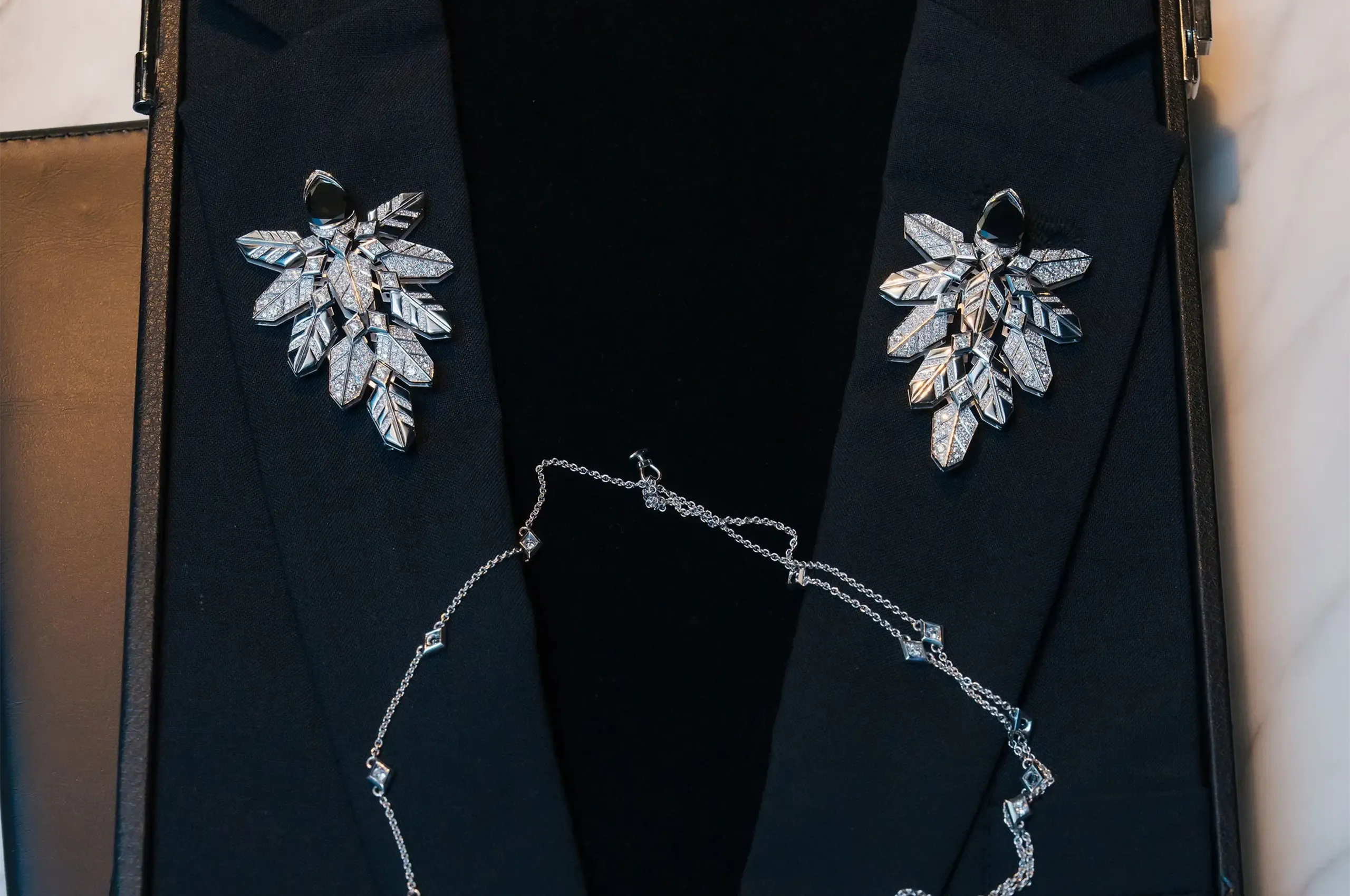 Inversari by Chantelle Green of Calleija features a pair of mirrored 18ct white gold lapel brooches inspired by feathers, shown without their detachable diamond-set chains