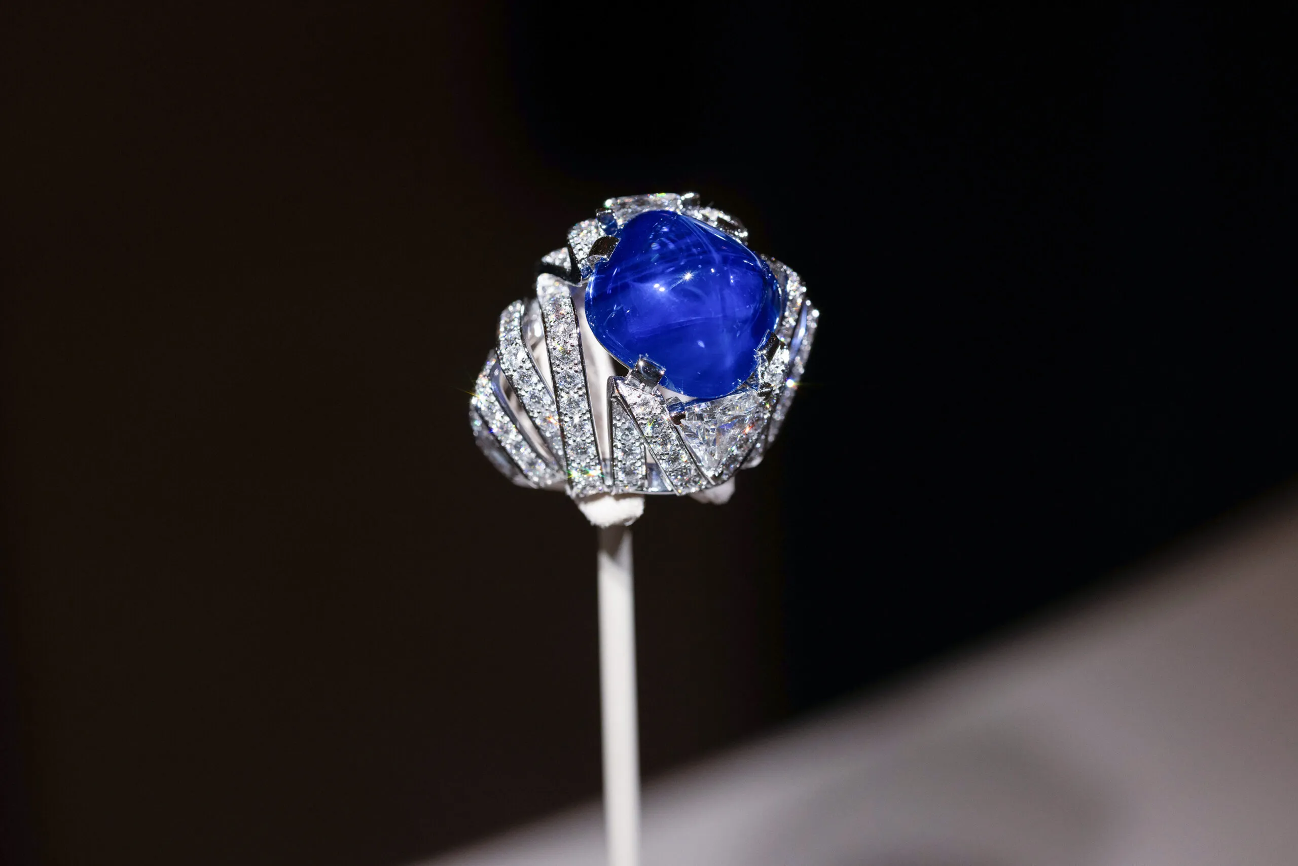 <p>Cartier ring with a 21.69-carat antique cushion-shaped cabochon-cut sapphire and two triangular-shaped modified brilliant-cut diamonds totalling 1.89 carats, set in platinum, part of the En Équilibre High Jewellery collection</p>