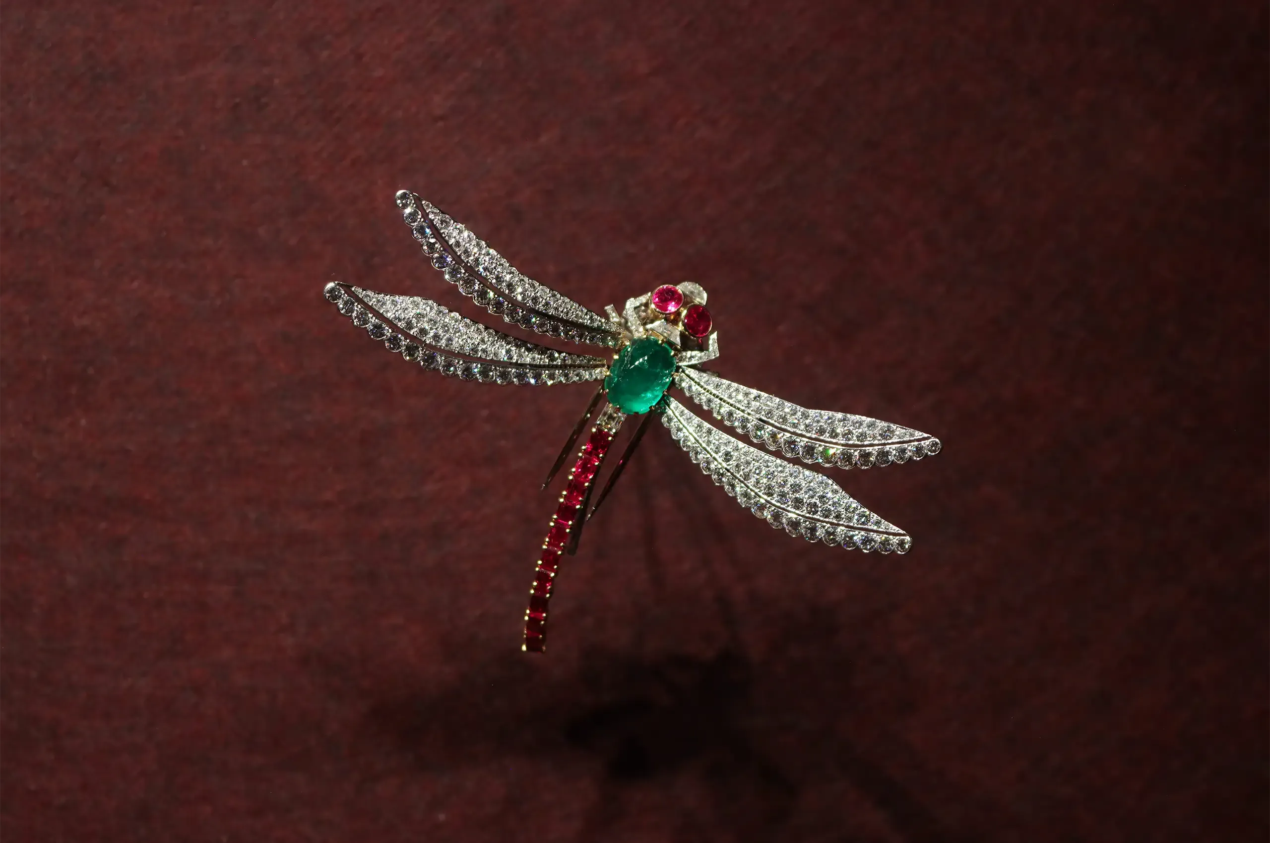 Cartier Dragonfly clip brooch, 1953, in platinum and gold, set with an emerald, rubies and diamonds, with spring-mounted wings designed to flutter with movement. Cartier Collection