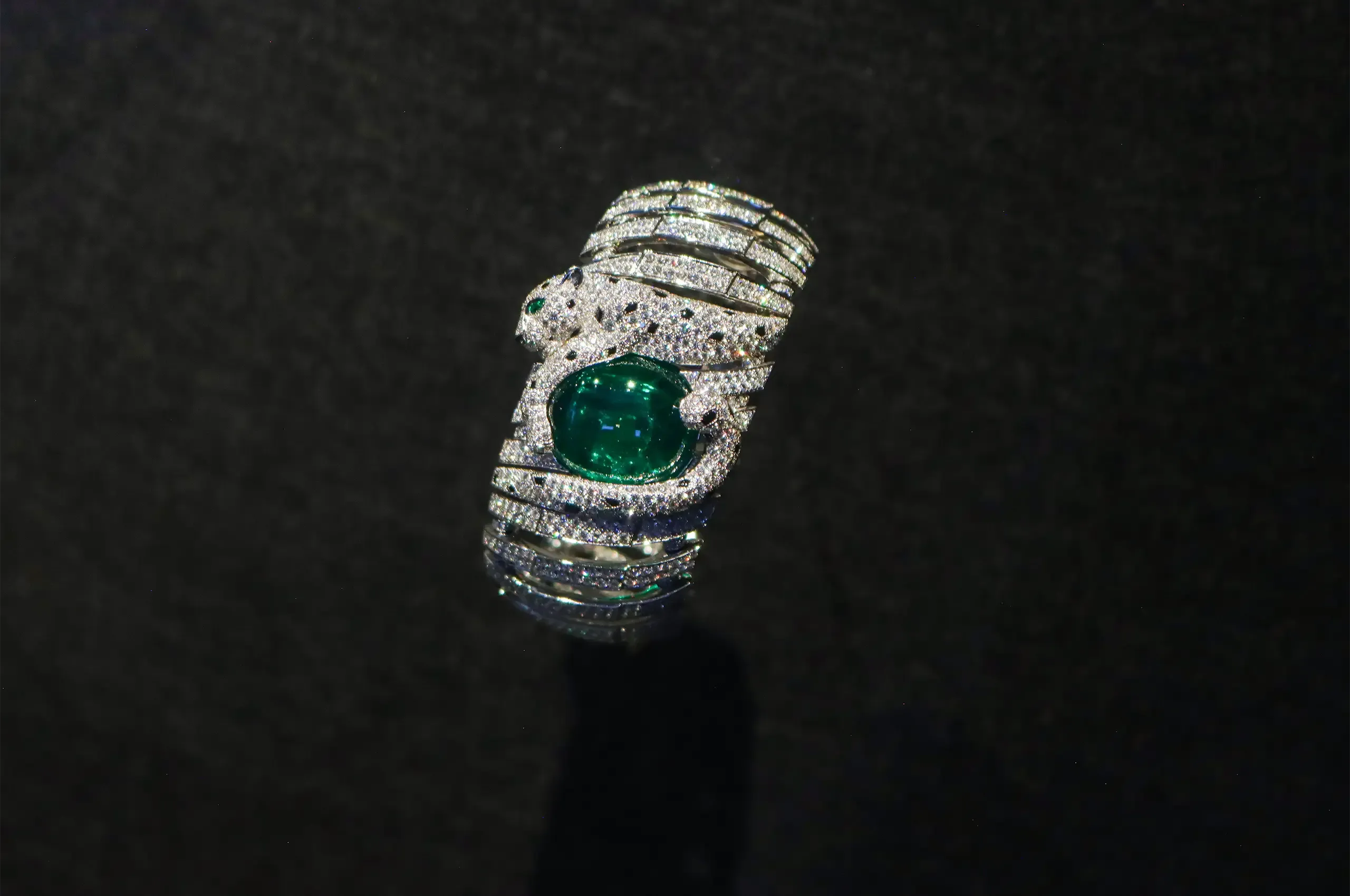 Cartier Panthère bracelet, with a diamond-set panther curled around a large cabochon emerald, accented with onyx and an emerald eye