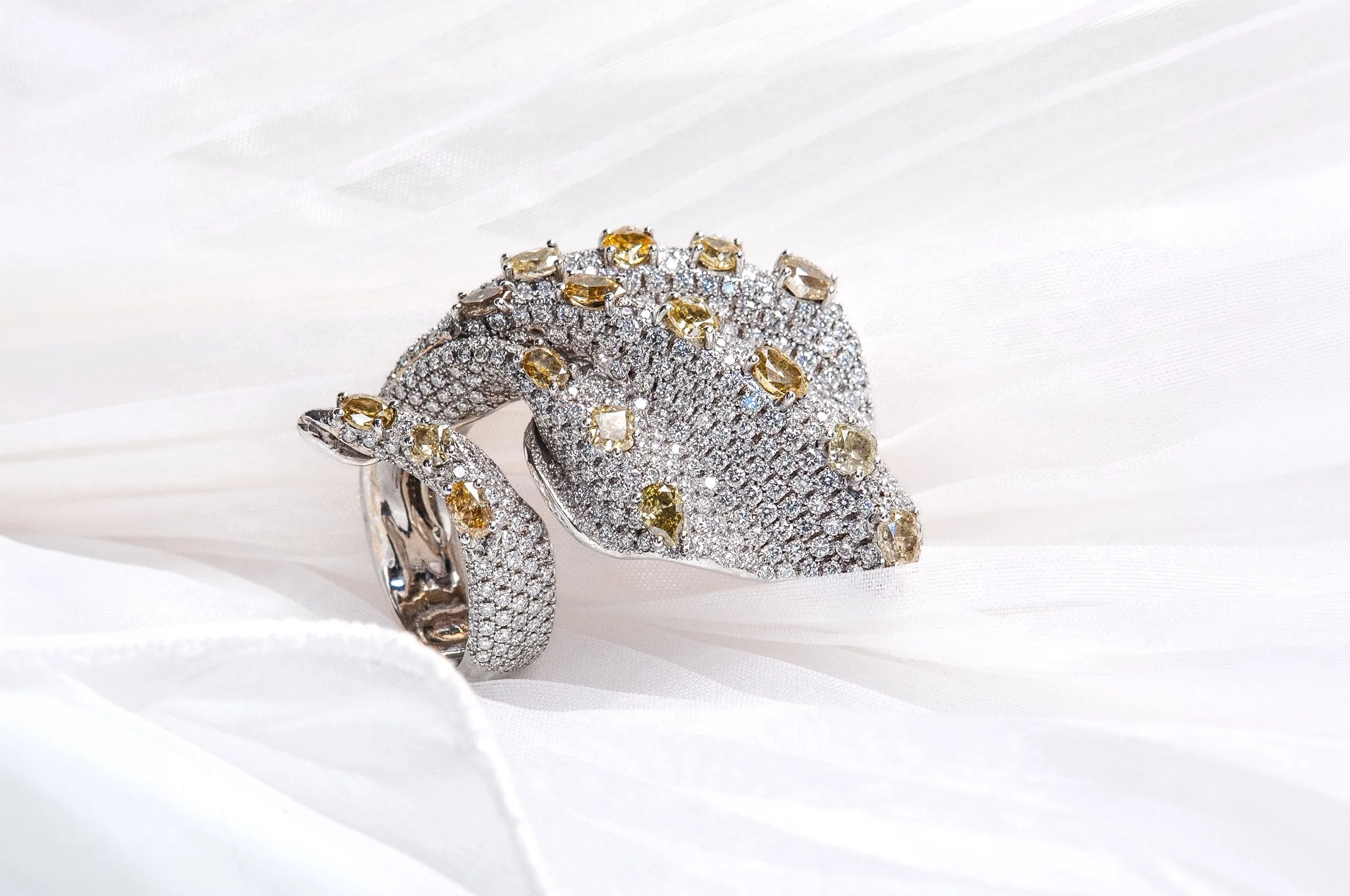An iconic ring from Maison d'Avossa, on whose white gold and diamond waves rest natural fancy diamonds in various cuts and shades