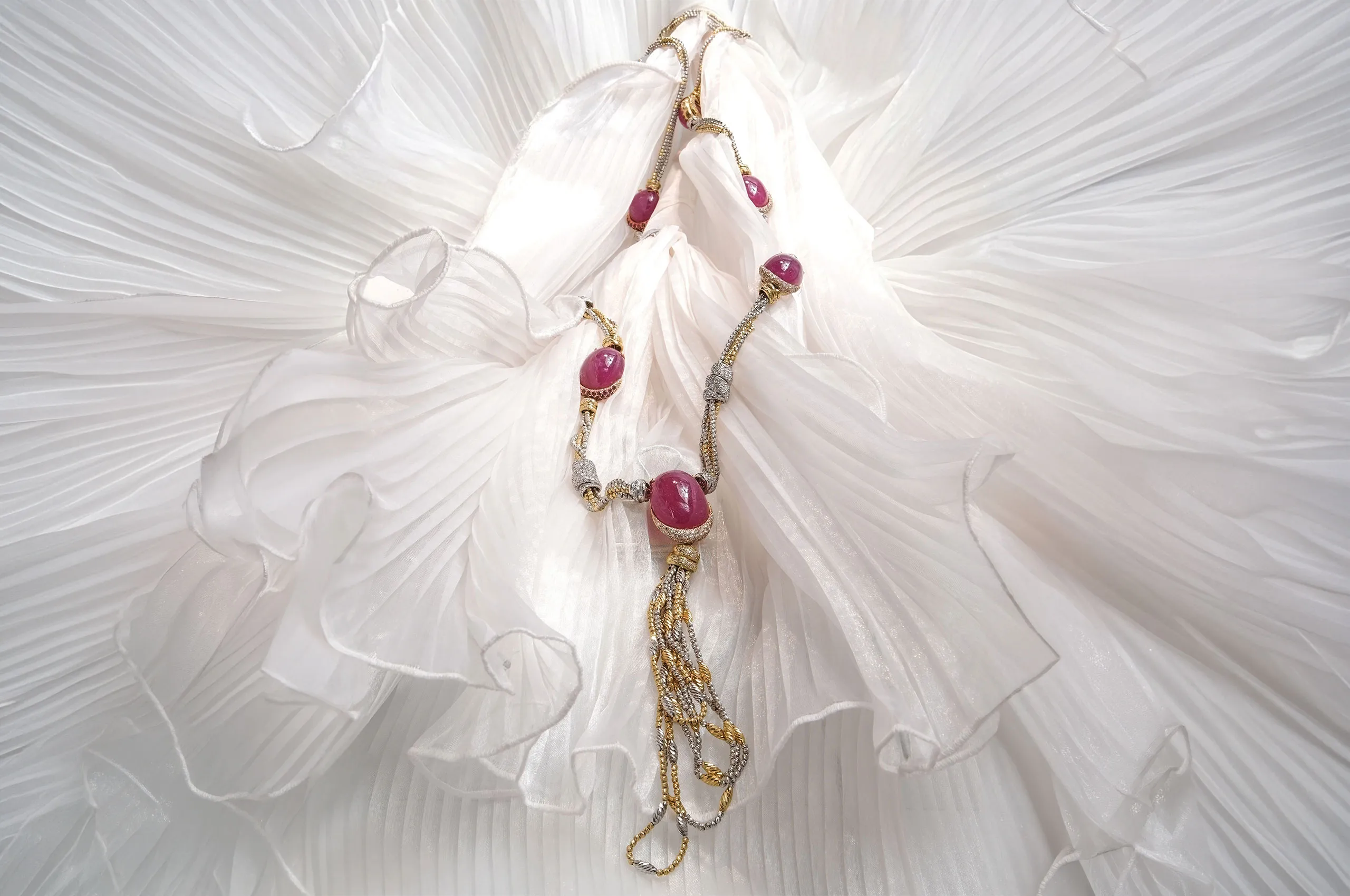 A unique creation, this long white and yellow gold d'Avossa necklace with is set with large natural cabochon rubies and embellished with densely pavéd diamond elements