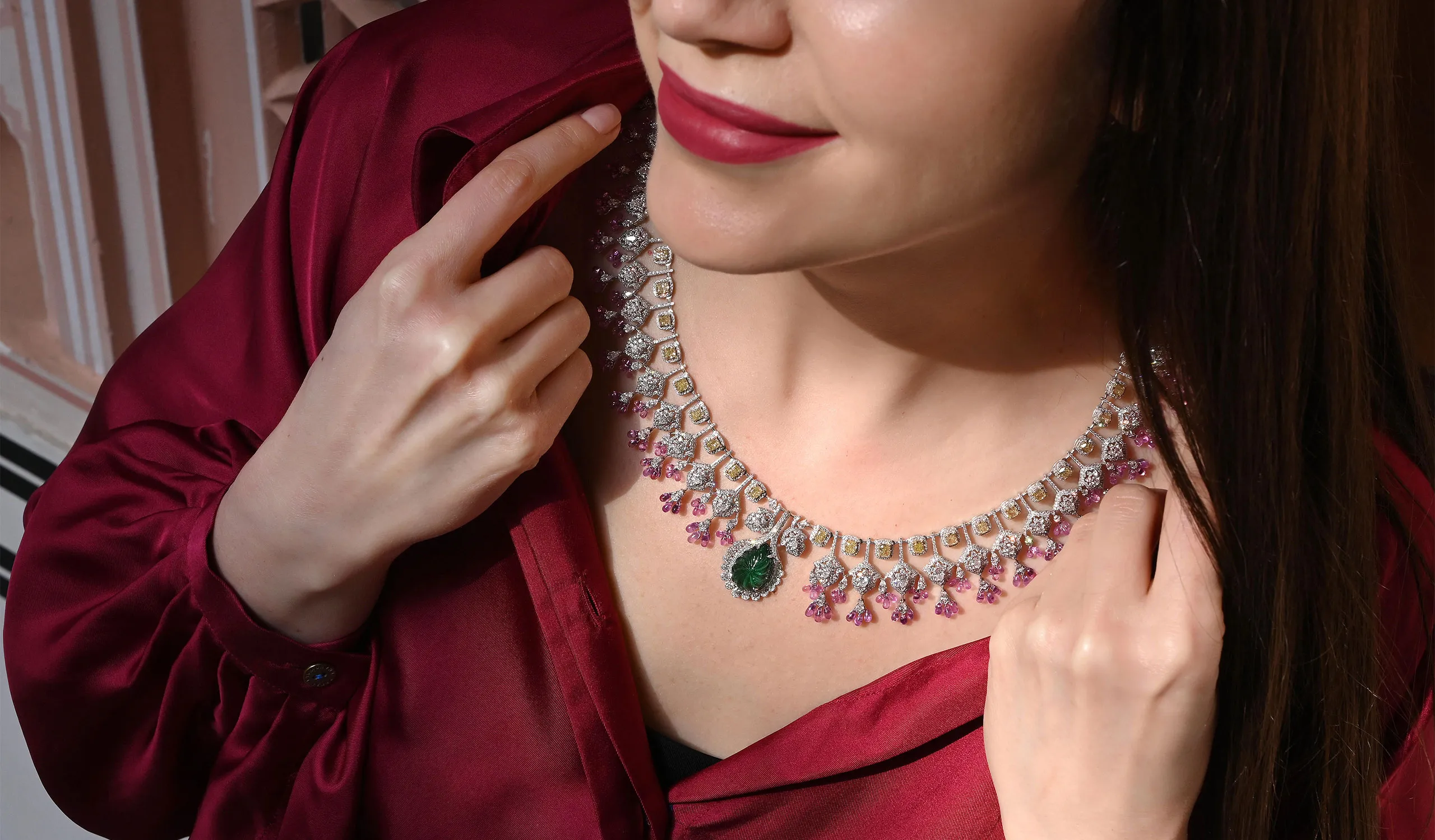 <p>Katerina Perez wears a High Jewellery necklace by Daviano, set with diamonds, pink sapphires, and a carved emerald focal point</p>