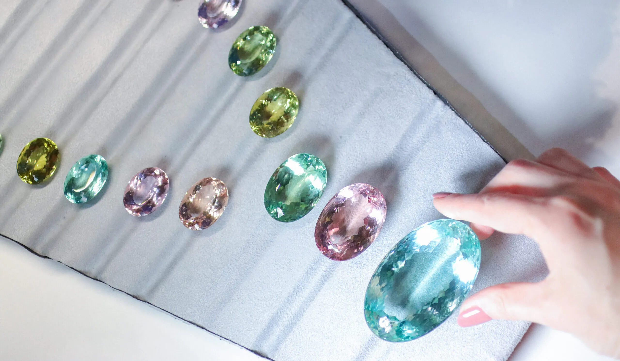 <p>At the booth of Filippo Gay, 17 oval stones from the beryl family – aquamarines, morganites, heliodors and green beryls – were laid out like a pastel rainbow</p>