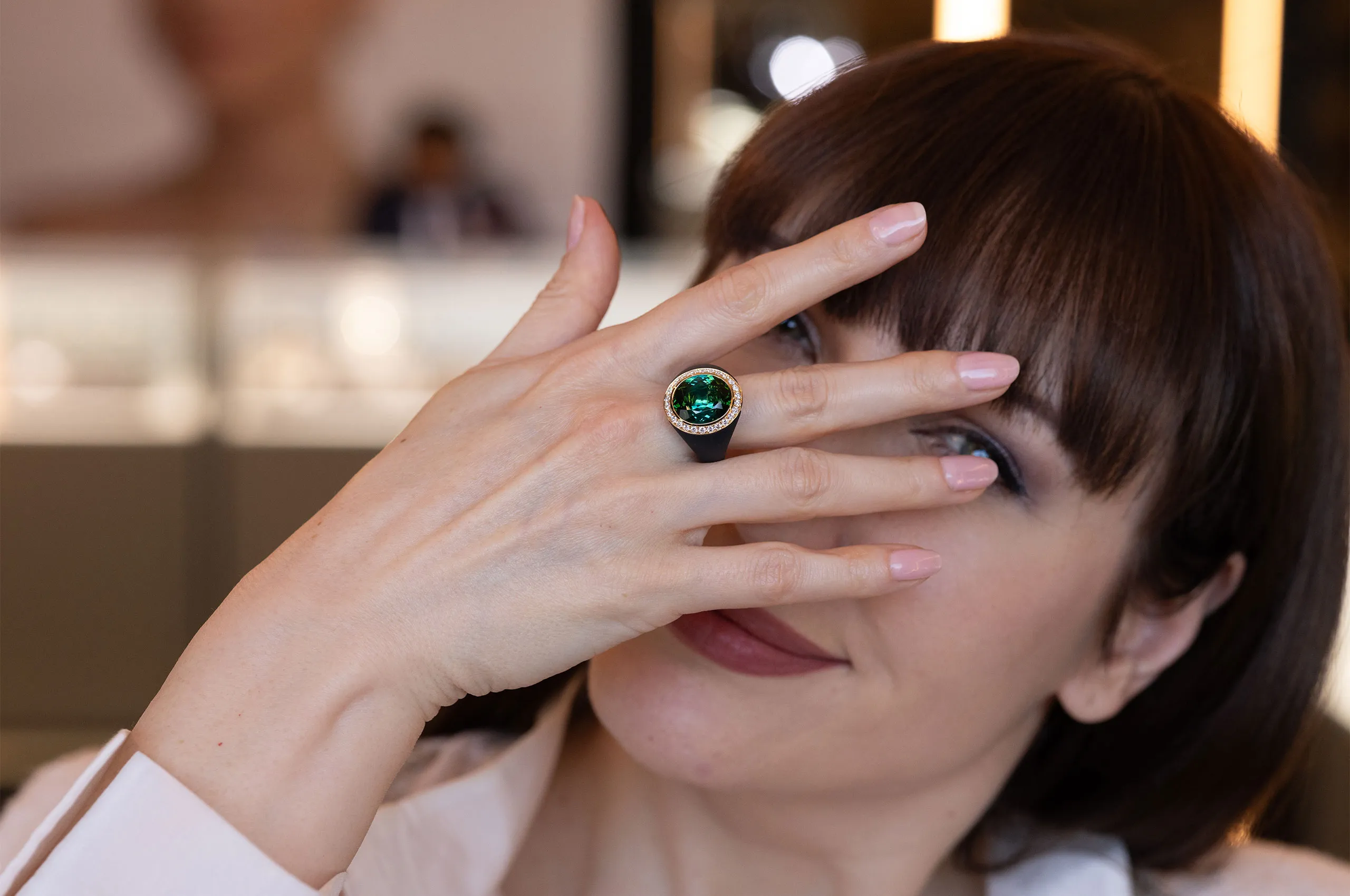 Katerina Perez wears a ring by Giorgio Visconti set with a central green tourmaline and diamonds in black titanium and rose gold 