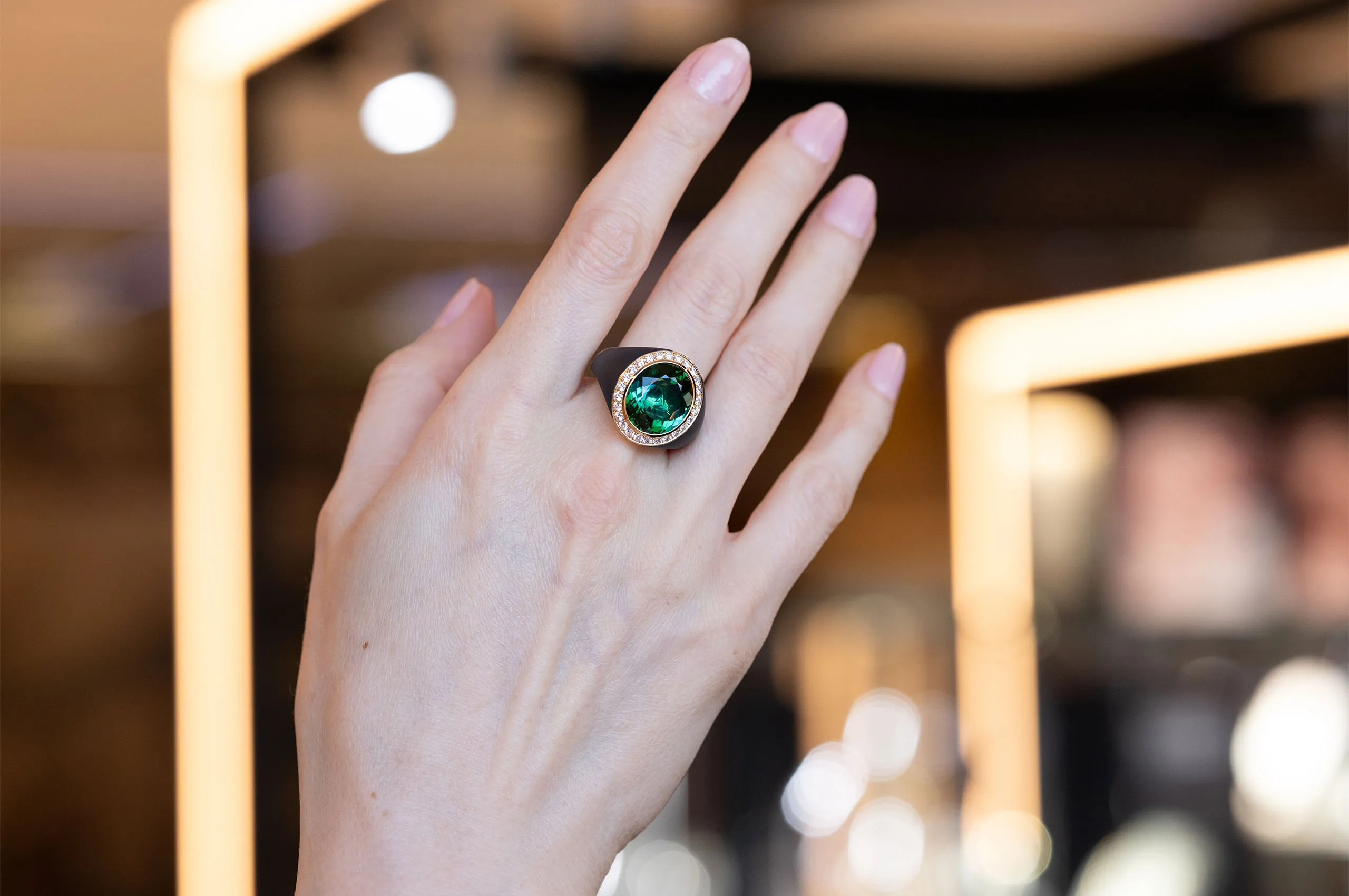 Katerina Perez showcases a ring by Giorgio Visconti set with a central green tourmaline and diamonds in black titanium and rose gold 