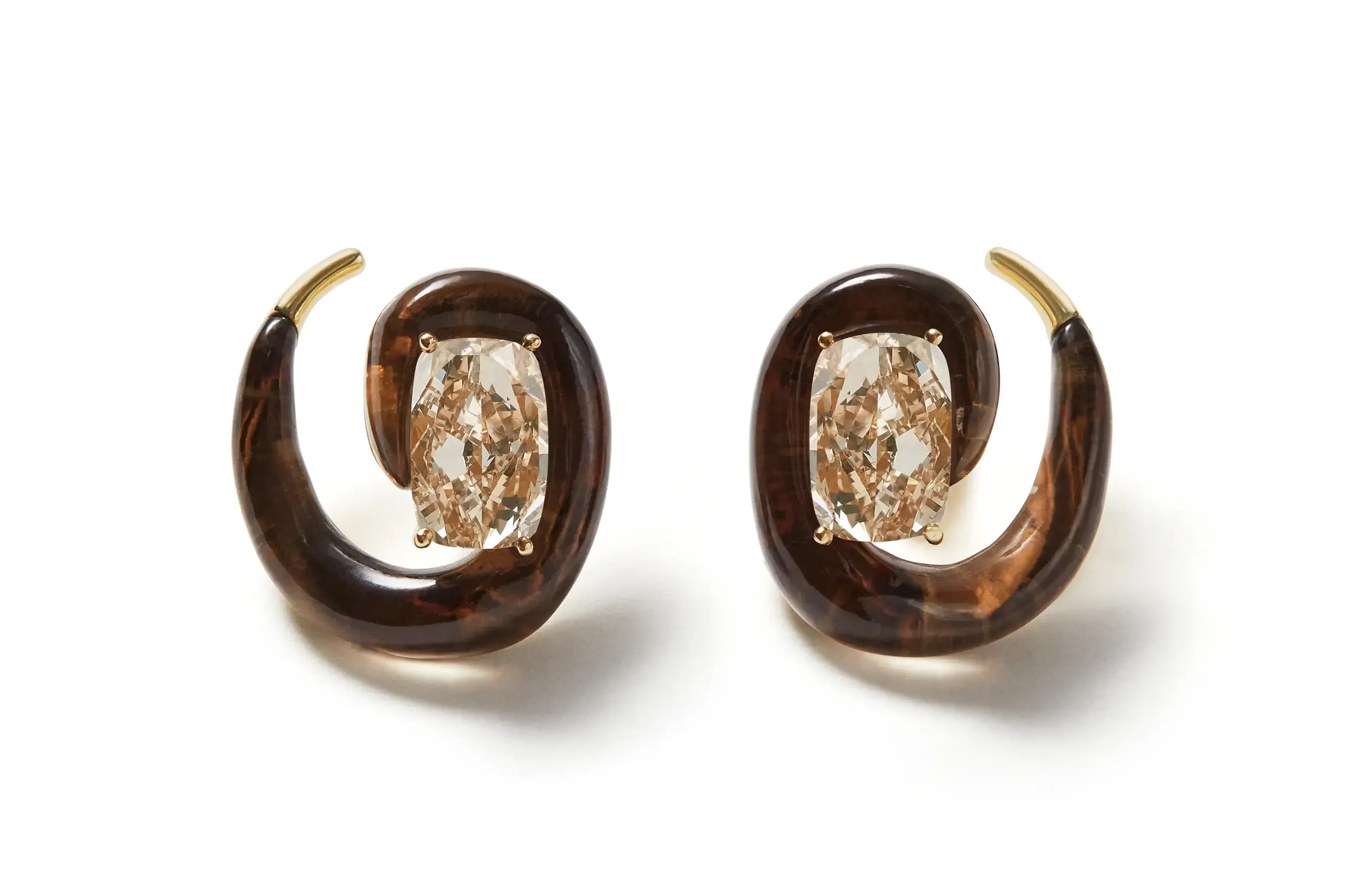 A creation by Fernando Jorge. Two faceted cushion cut brown diamond surrounded by hand-carved smoky quartz and set in 18k yellow.