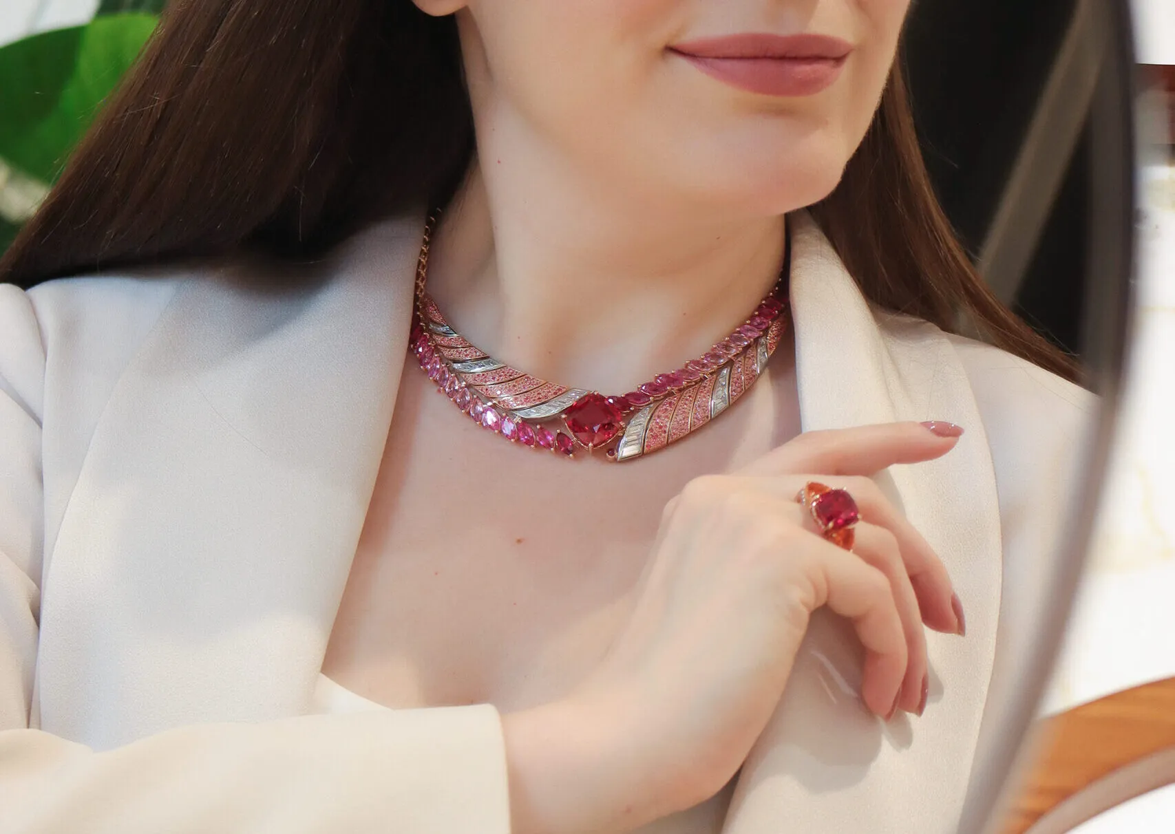 <p>Katerina Perez wears the Tanzanian Sunrise High Jewellery necklace from the House of Gübelin with a 22 carat cushion-shaped red spinel, diamonds, spinels, sapphires and rubies, alongside the Classics cocktail ring with a central spinel, mandarin garnets and diamonds</p>

