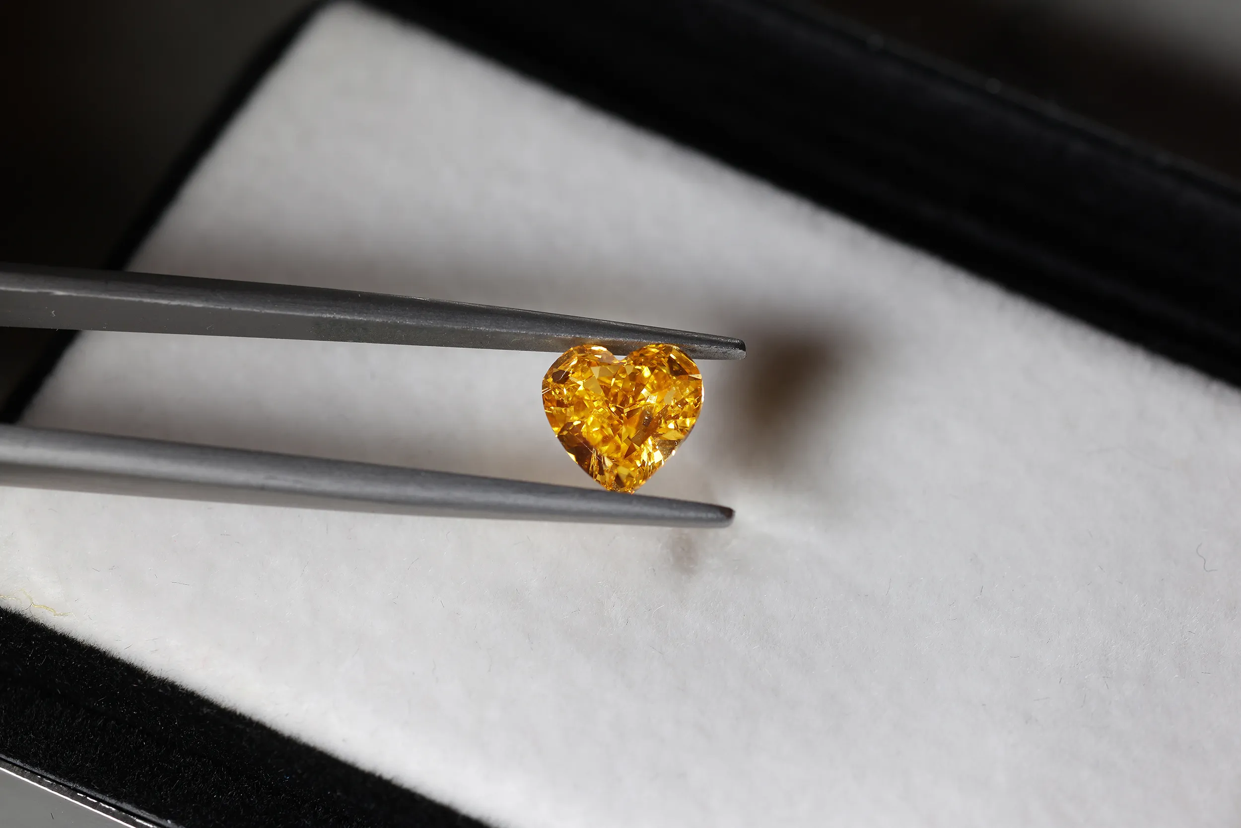 <p>A closer look at the Fancy Vivid Yellow-Orange heart shape diamond</p>
