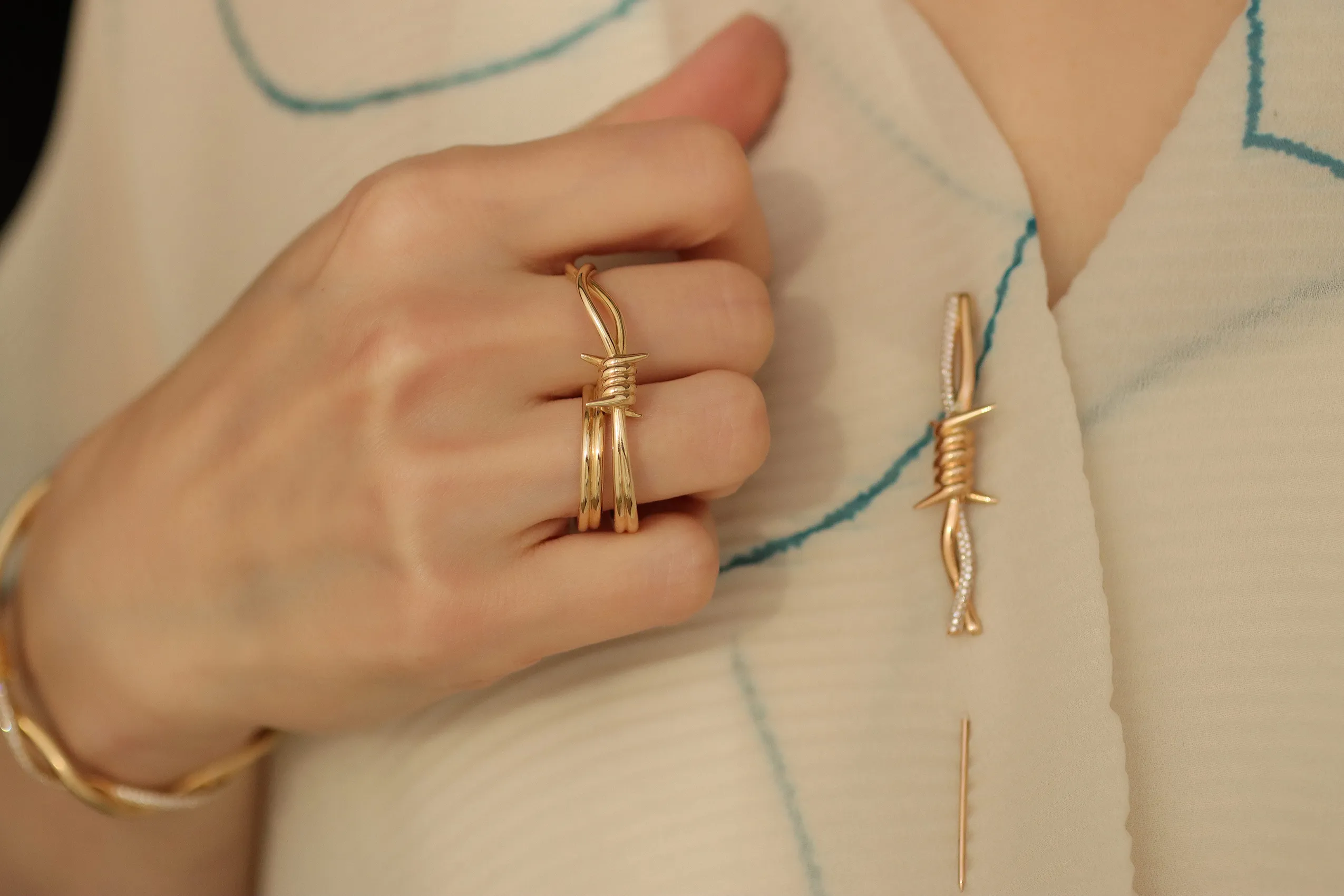 <p>A brooch and two-finger ring in 18k yellow gold with diamonds from Moody Jewellery’s Wethaq collection</p>