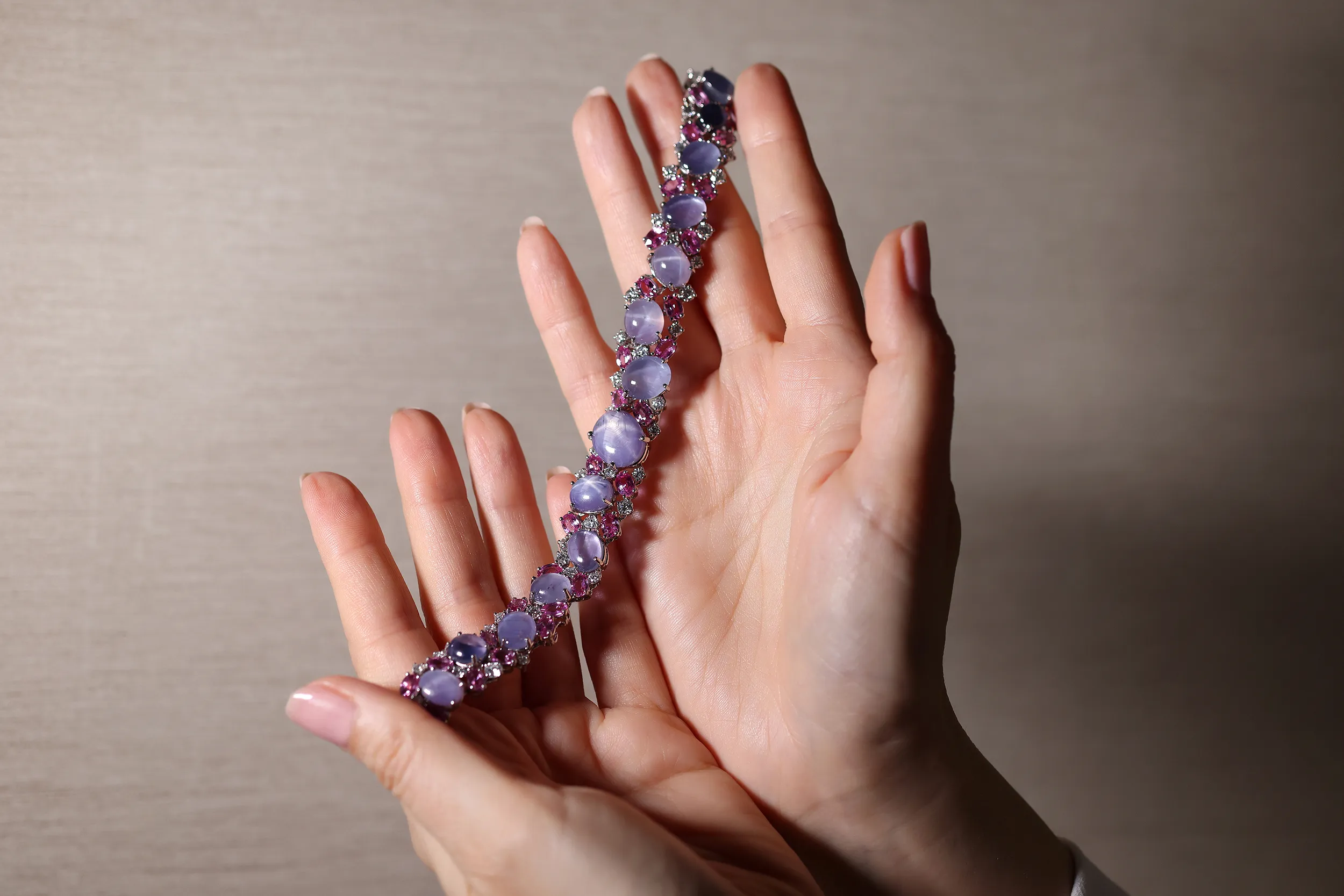 <p>An exquisite star sapphire bracelet, set with 14 oval star sapphires totalling 82.61ct, pink sapphires and diamonds</p>

