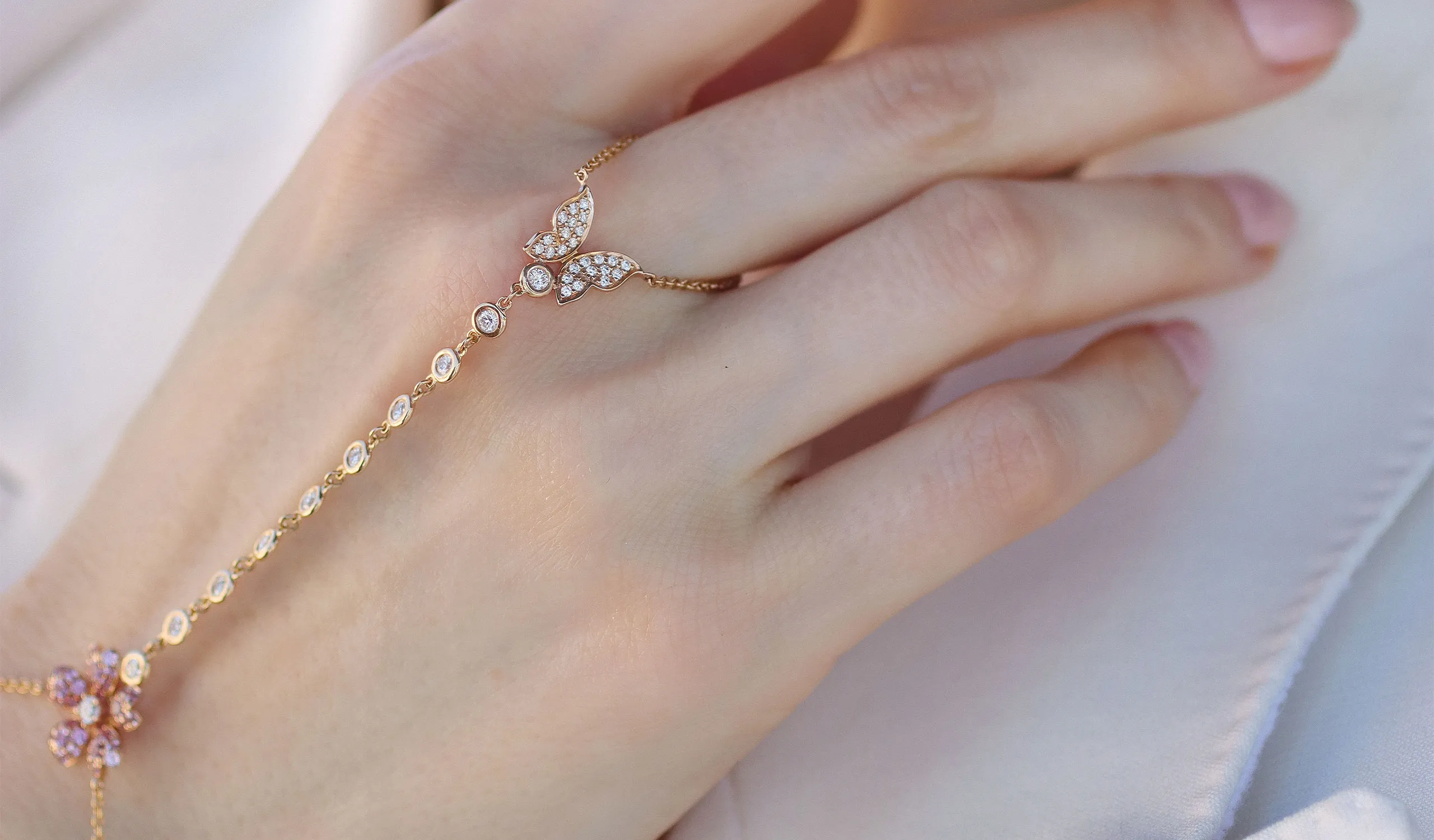 <p>A closer look at the details of a Lisa Nik hand chain from the Rainbow collection, set with pink sapphires and diamonds in 18k rose gold</p>
