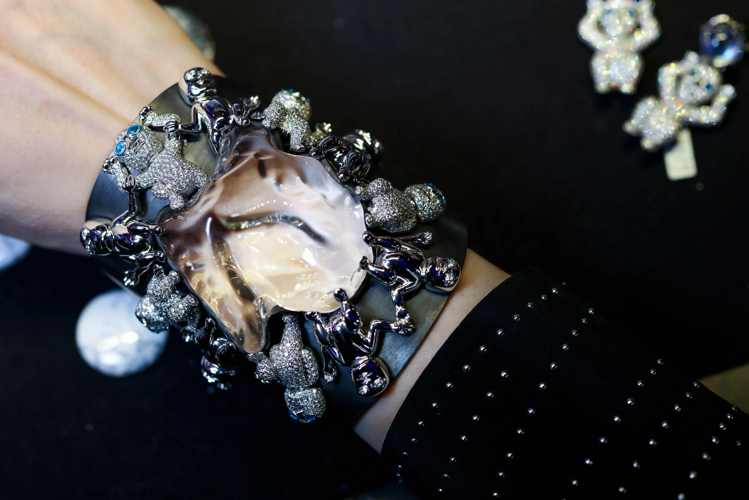 <p>The White Paradise cuff features a freeform rock crystal that represents the mythical Sky World, encircled by watchful silver and diamond guardian figures with apatite eyes</p>
