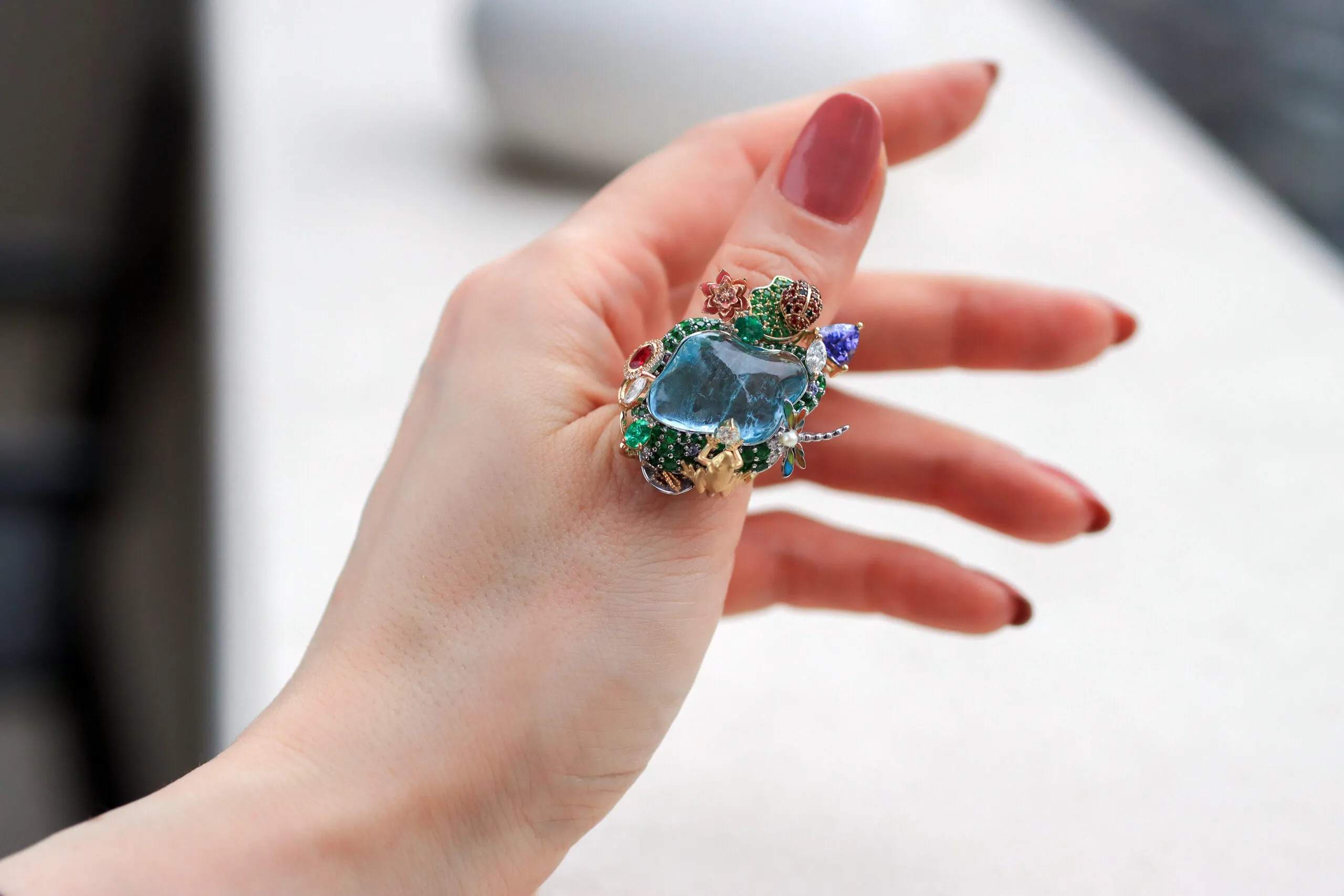 <p>Mariyeh Ghelichkhani’s Hayat ring with a 22-carat aquamarine surrounded by a gem-set water lily, lotus flower, frog, dragonfly and ladybug is inspired by a cherished pond at her family’s holiday home</p>
