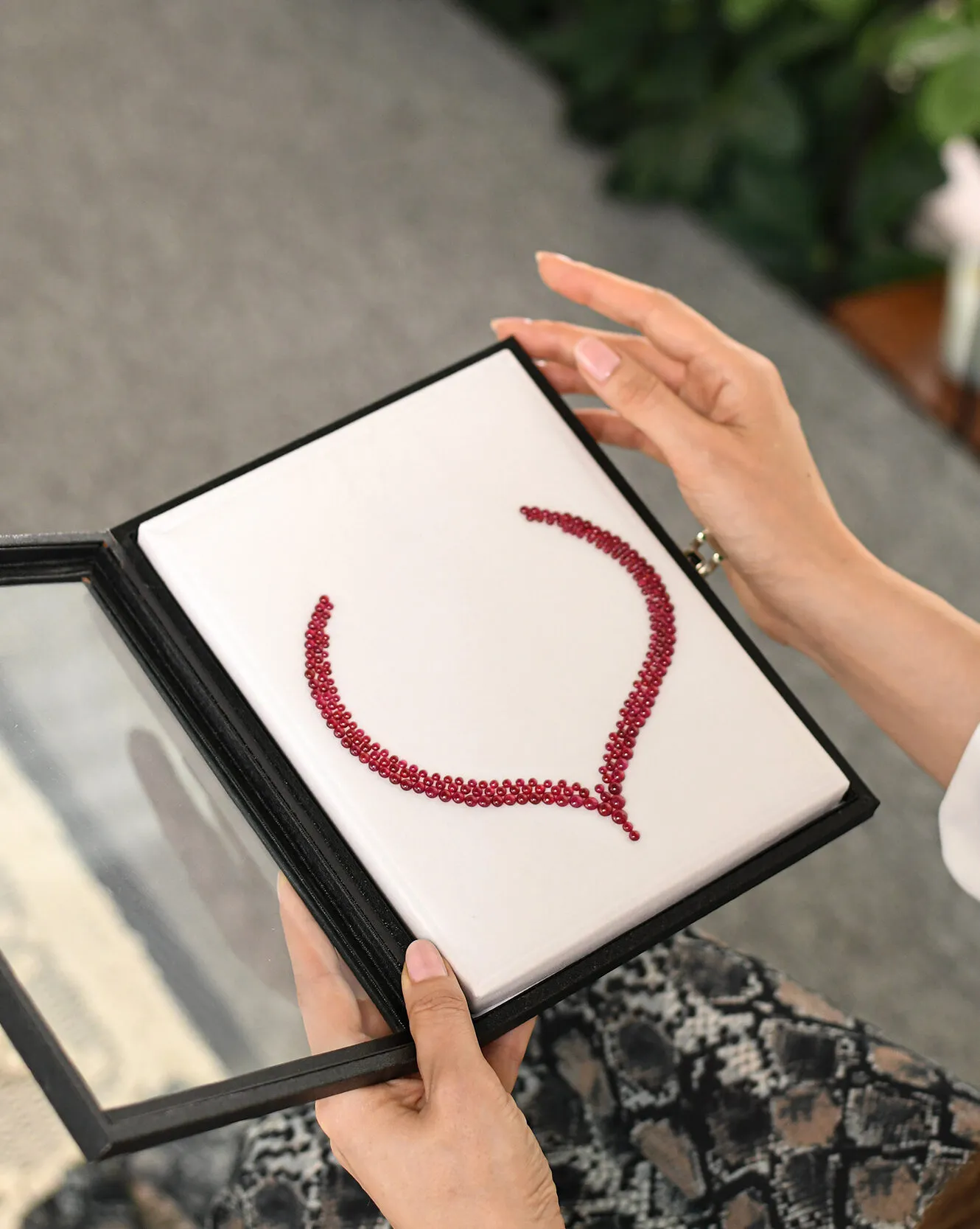 <p>Katerina Perez considers a layout of cabochon rubies perfectly matched by colour and carat weight, presented during a visit to Jaipur-based gem-cutting company Minehaus</p>
