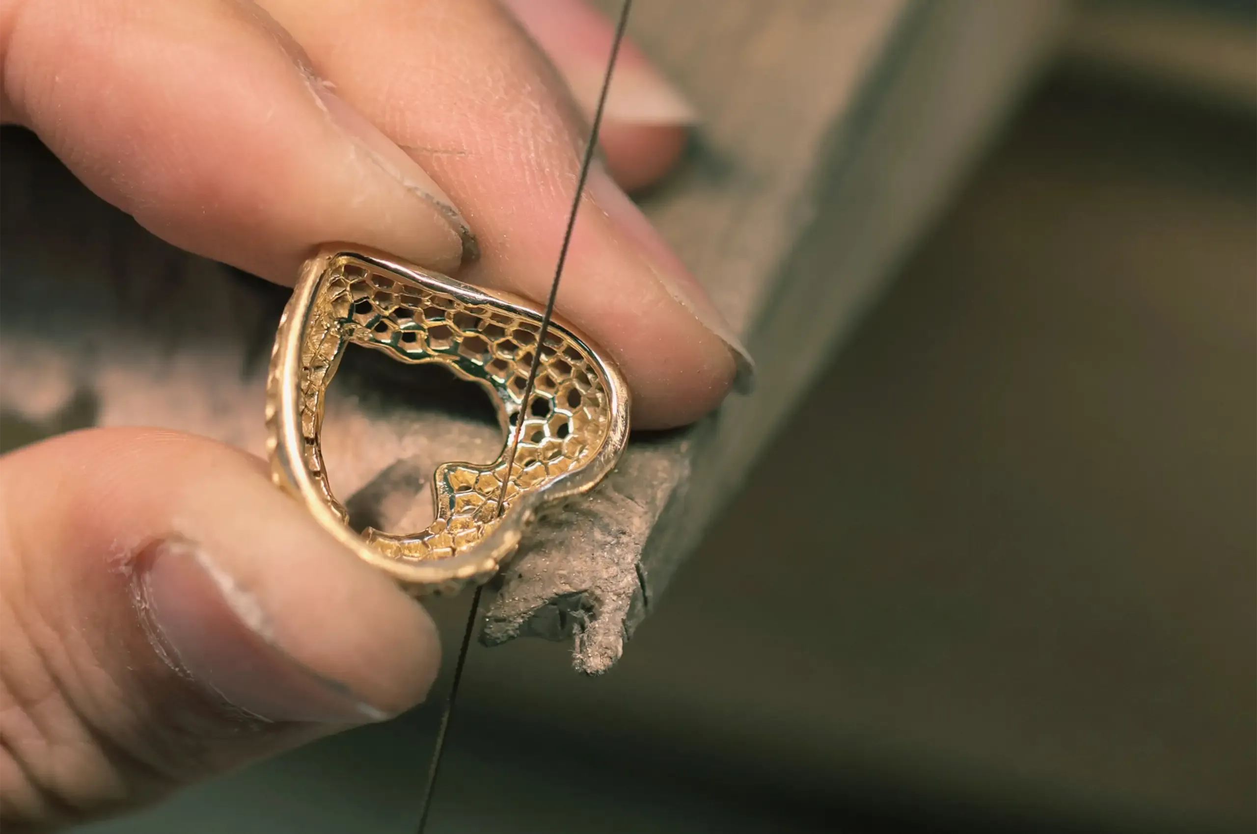 Hand-piercing the openwork structure of a gold jewel