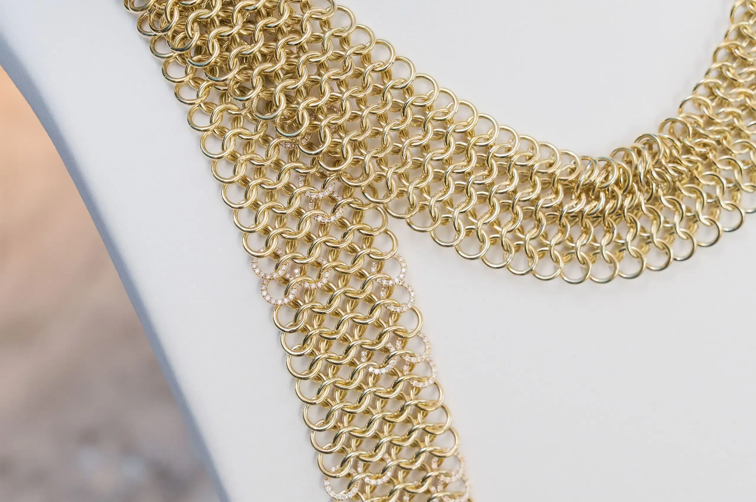A close-up of Draped by Nadia Neuman, showing the interlocking gold links that give the jewellery scarf its fluid, textile-like quality