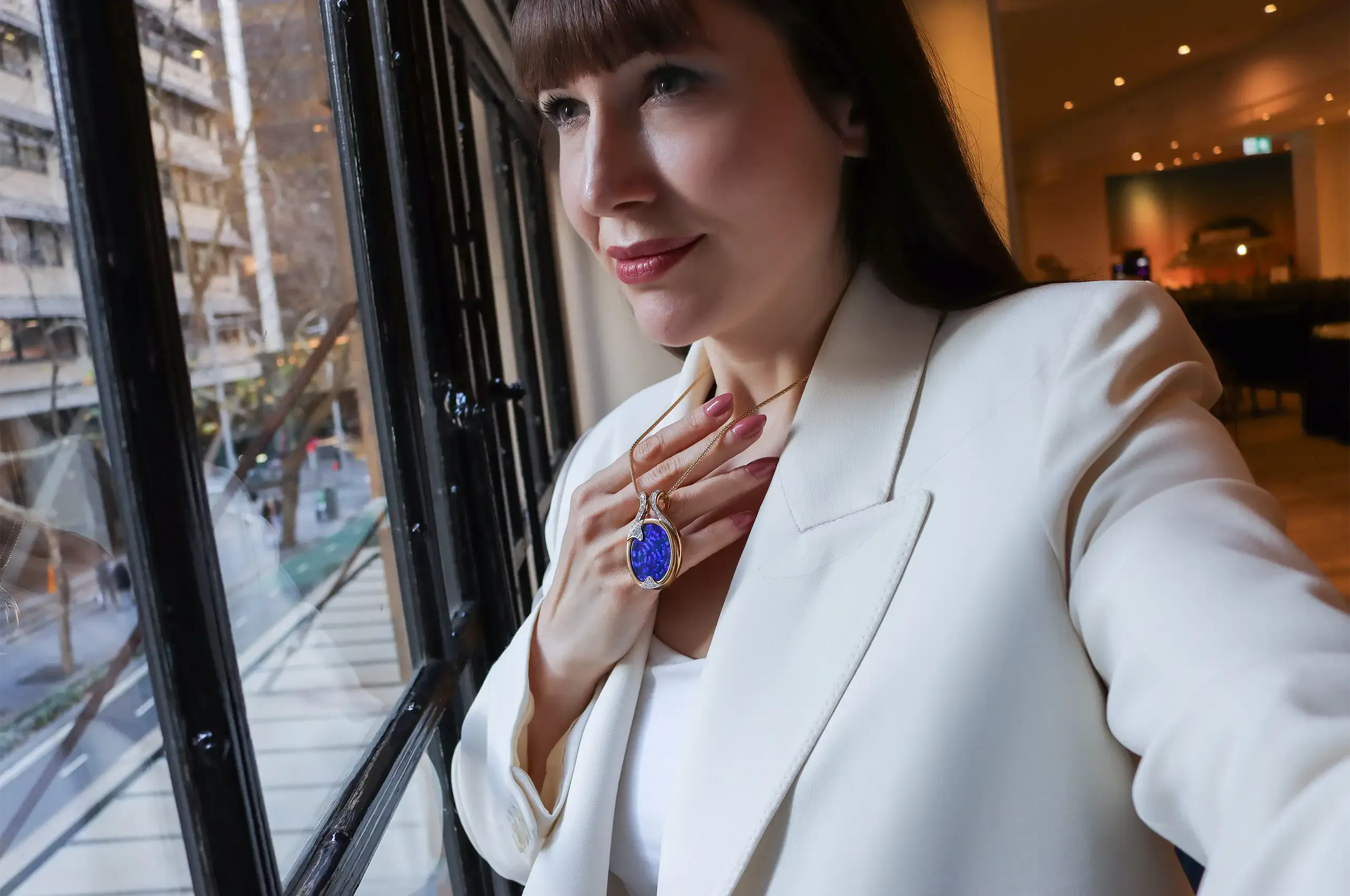 Katerina wears Olivia Chan's one-of-a-kind pendant, set with a rare Peacock Tail 36.80-carat Australian black opal
