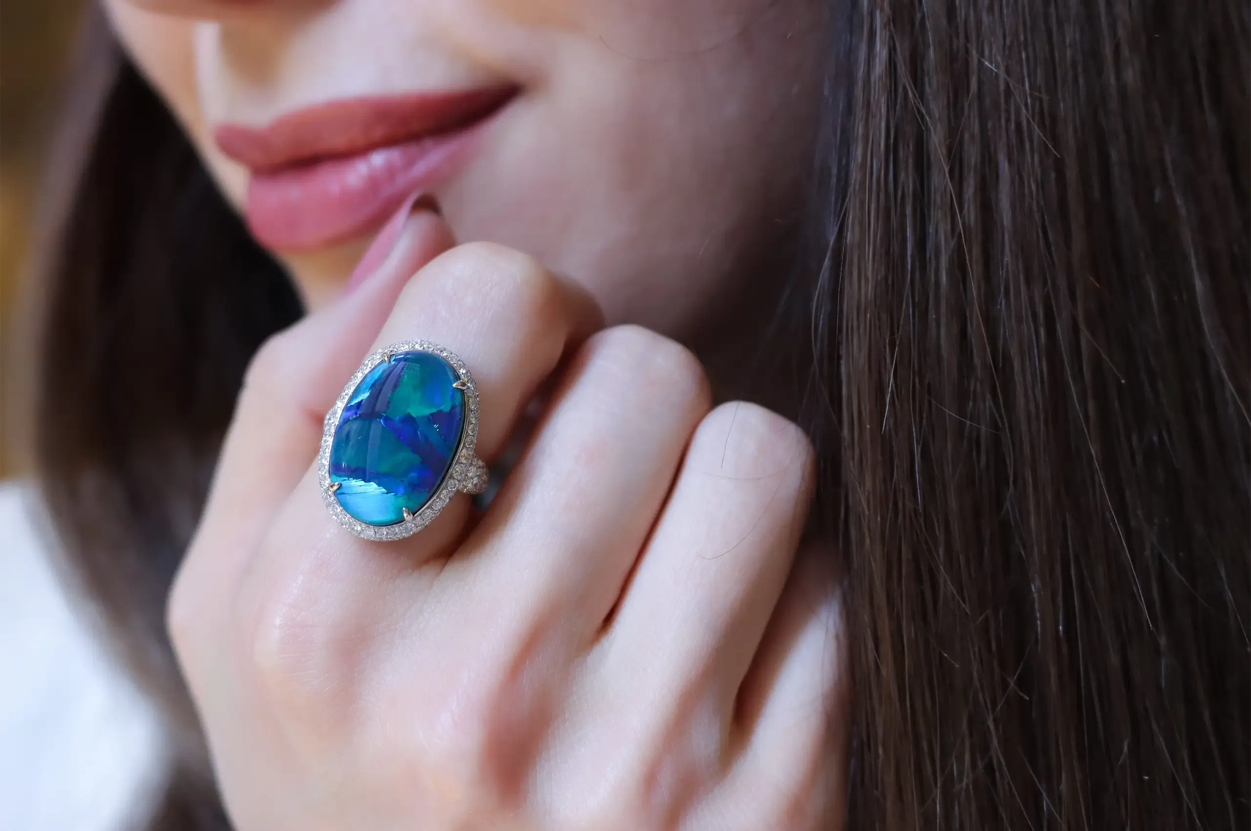 The painterly colours of an 8.21-carat Australian black opal with a rare Flagstone pattern, set alongside 1.50 carats of diamonds in 18k white gold