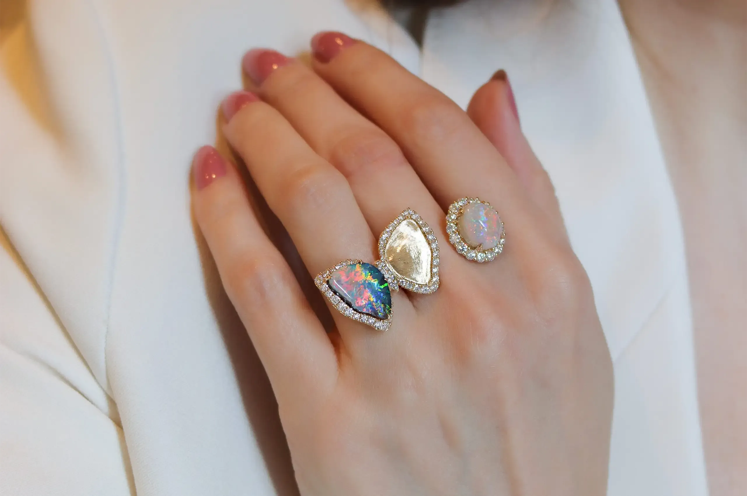A 5-carat boulder opal becomes one wing of a golden butterfly in Olivia Chan’s two-finger ring, with a 3.5-carat black opal set opposite