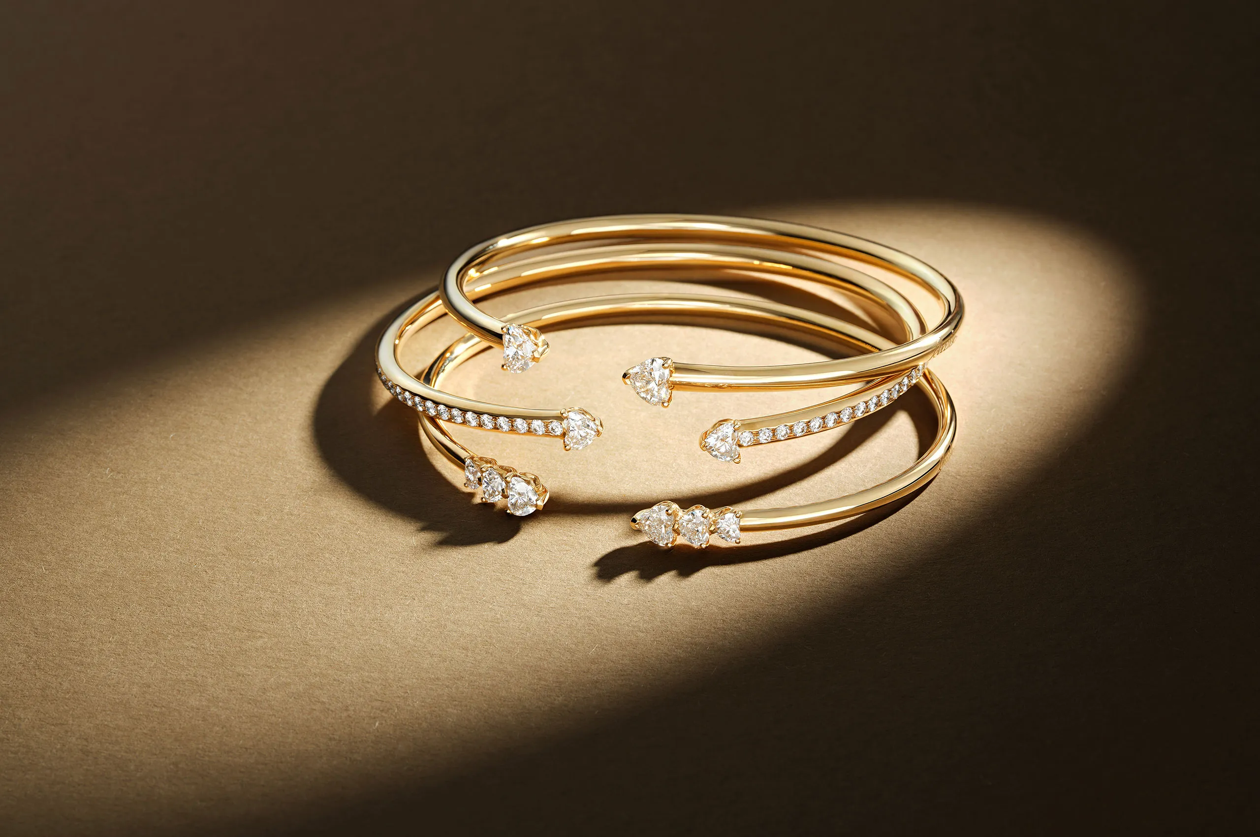 A stack of heart-shaped diamond More bracelets in 18k yellow gold by Recarlo