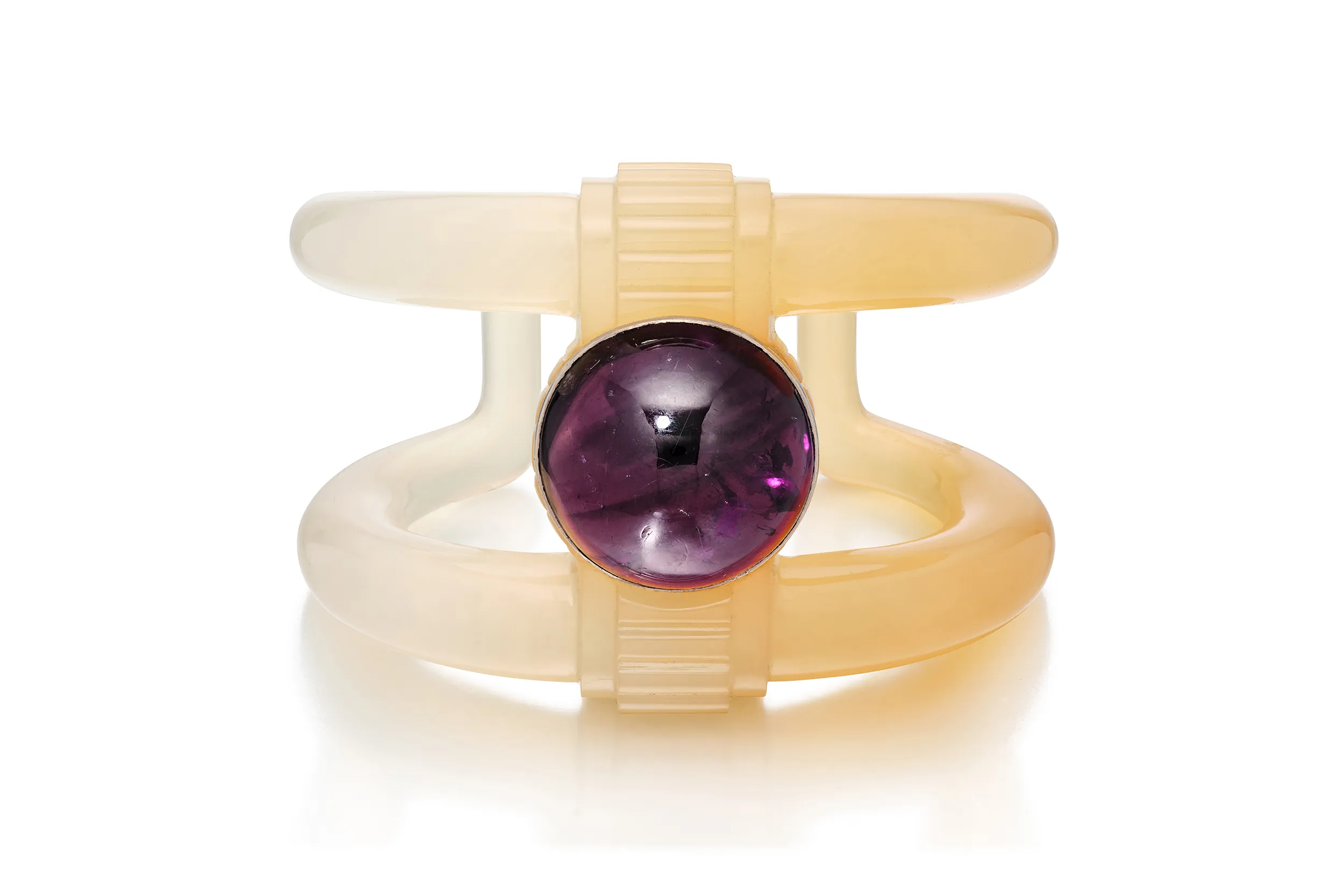 <p>Suzanne Belperron cuff bracelet in two-tone carved chalcedony with a round amethyst cabochon</p>